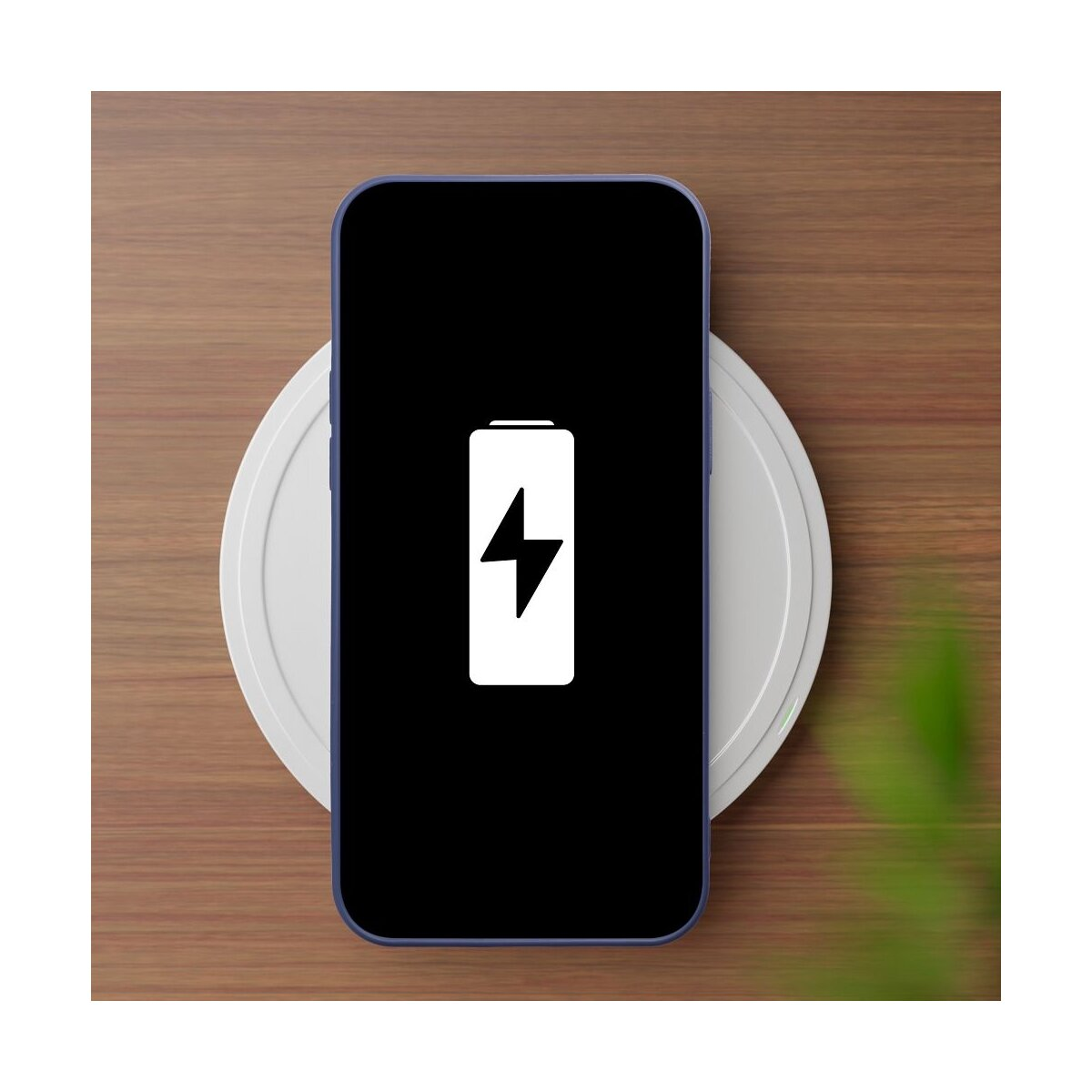Ein schwarzes Smartphone mit Akku-Ladeanzeige auf einem weißen kabellosen Ladegerät.