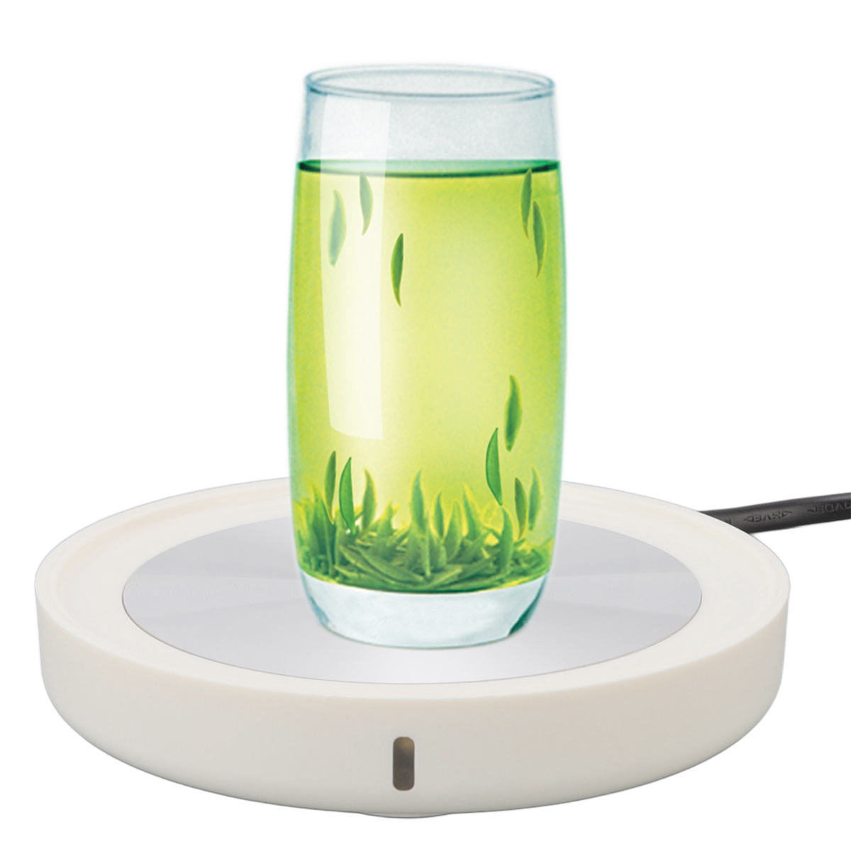 Ein Glas Grüntee steht auf einem weißen Tee-Wärmer.