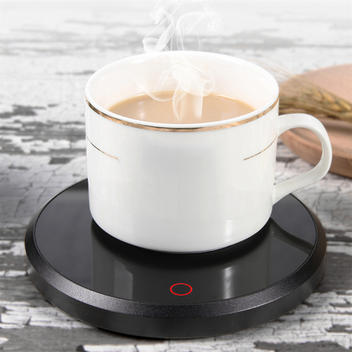 Eine weiße Tasse mit Kaffee steht auf einem schwarzen, runden Kaffee-Wärmer mit rotem Licht.