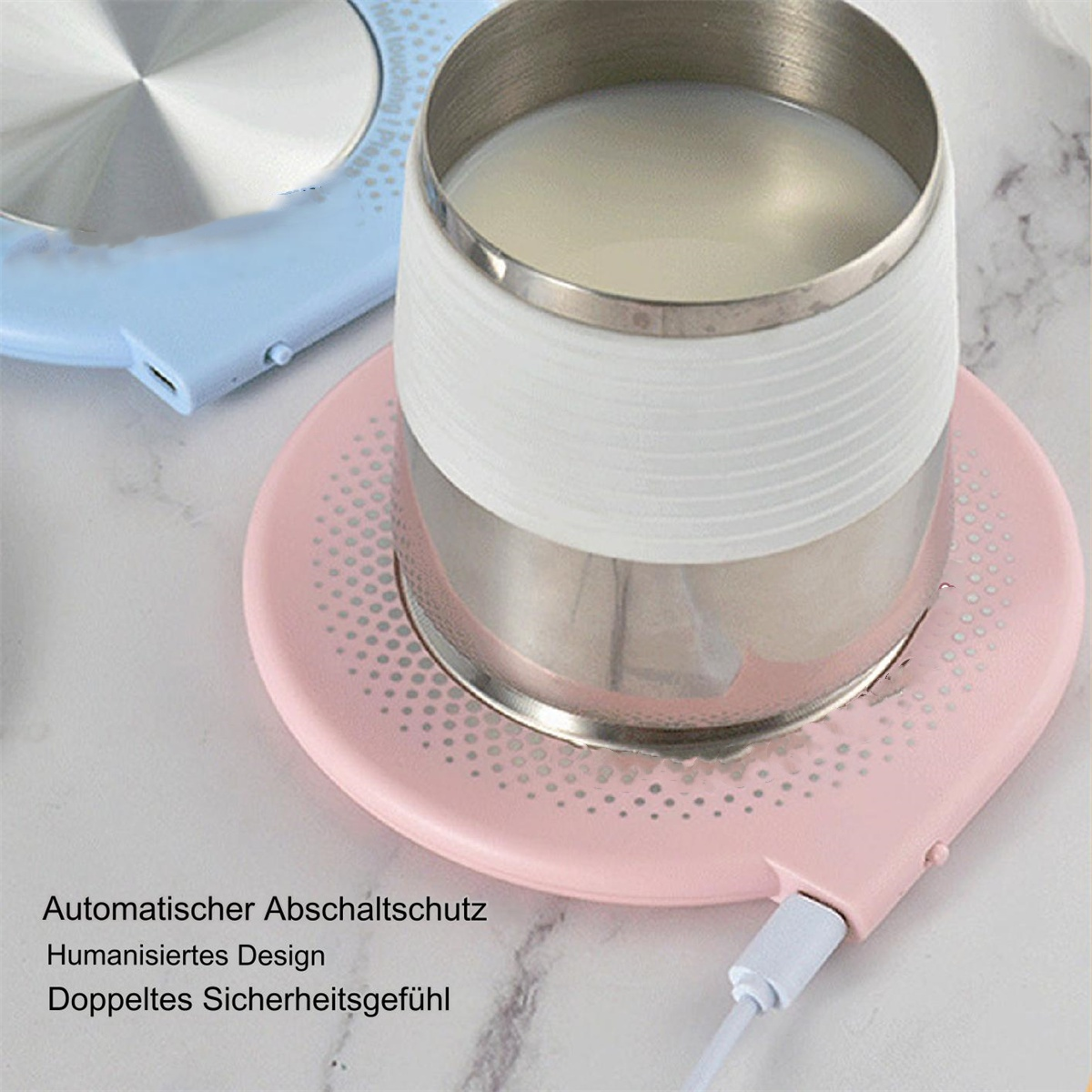 Rosa beheizter Untersetzer mit einem Glas Milch darauf. Blauer Untersetzer im Hintergrund. Weiße Oberfläche.