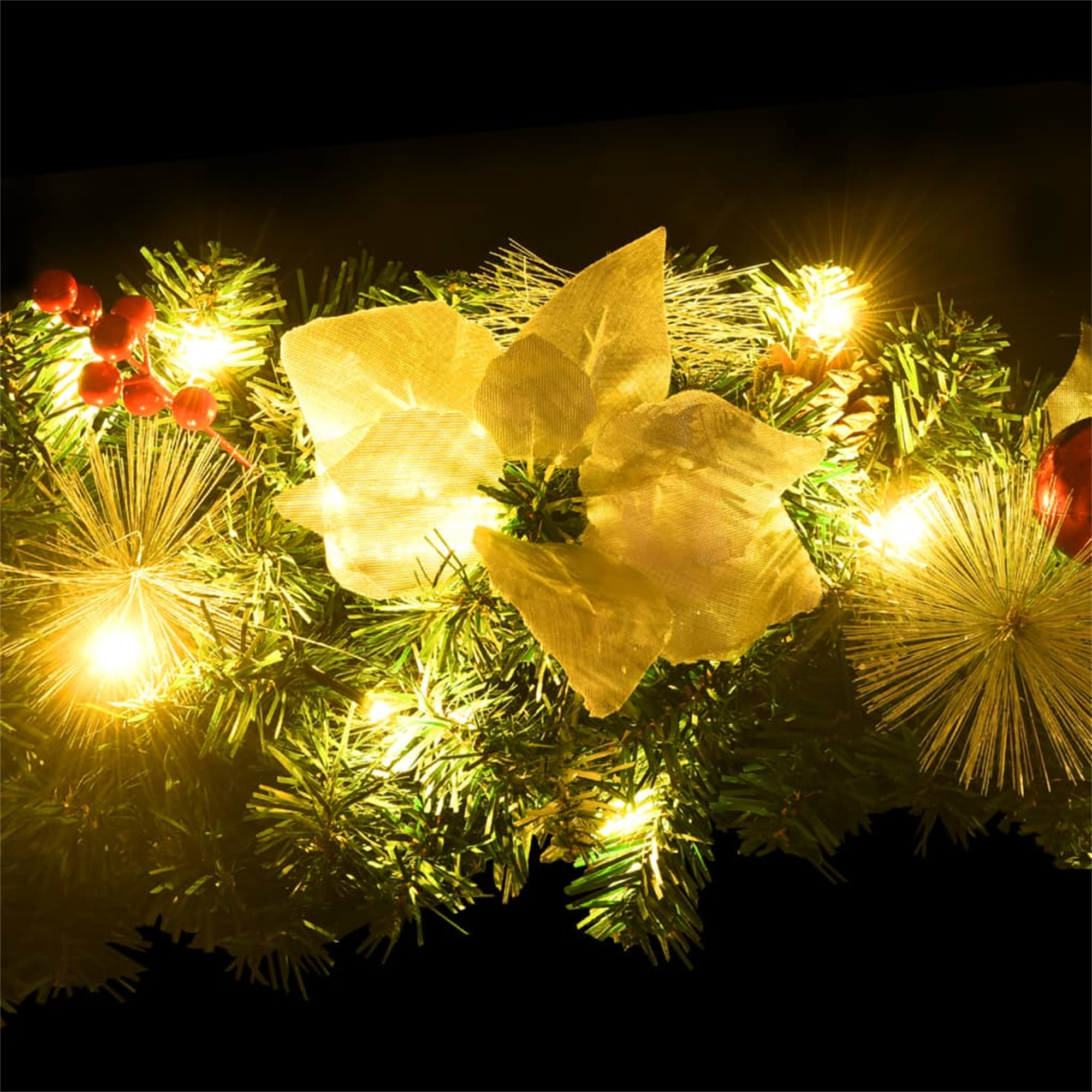 Weihnachtsgirlande mit Lichtern und Ornamenten. Schwarzer Hintergrund.