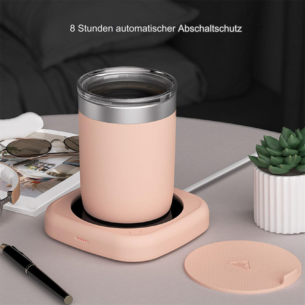 Ein rosa Becherwärmer mit einem Becher darauf und einem Deckel.