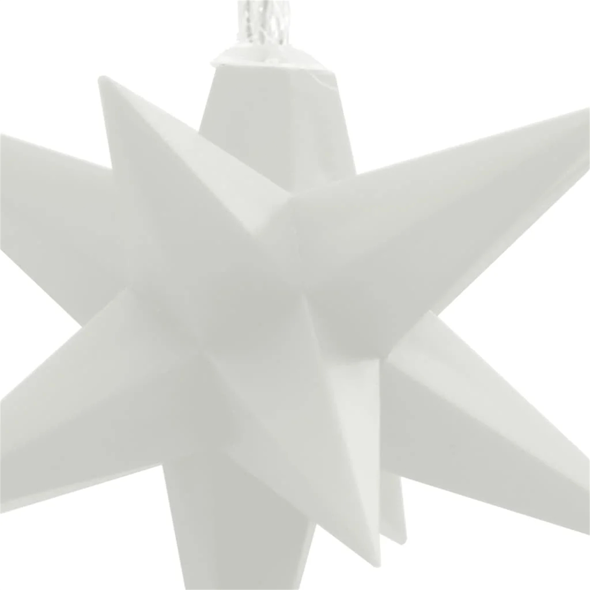 Ein weißer sternförmiger Weihnachtsschmuck hängt vor weißem Hintergrund, Nahaufnahme.