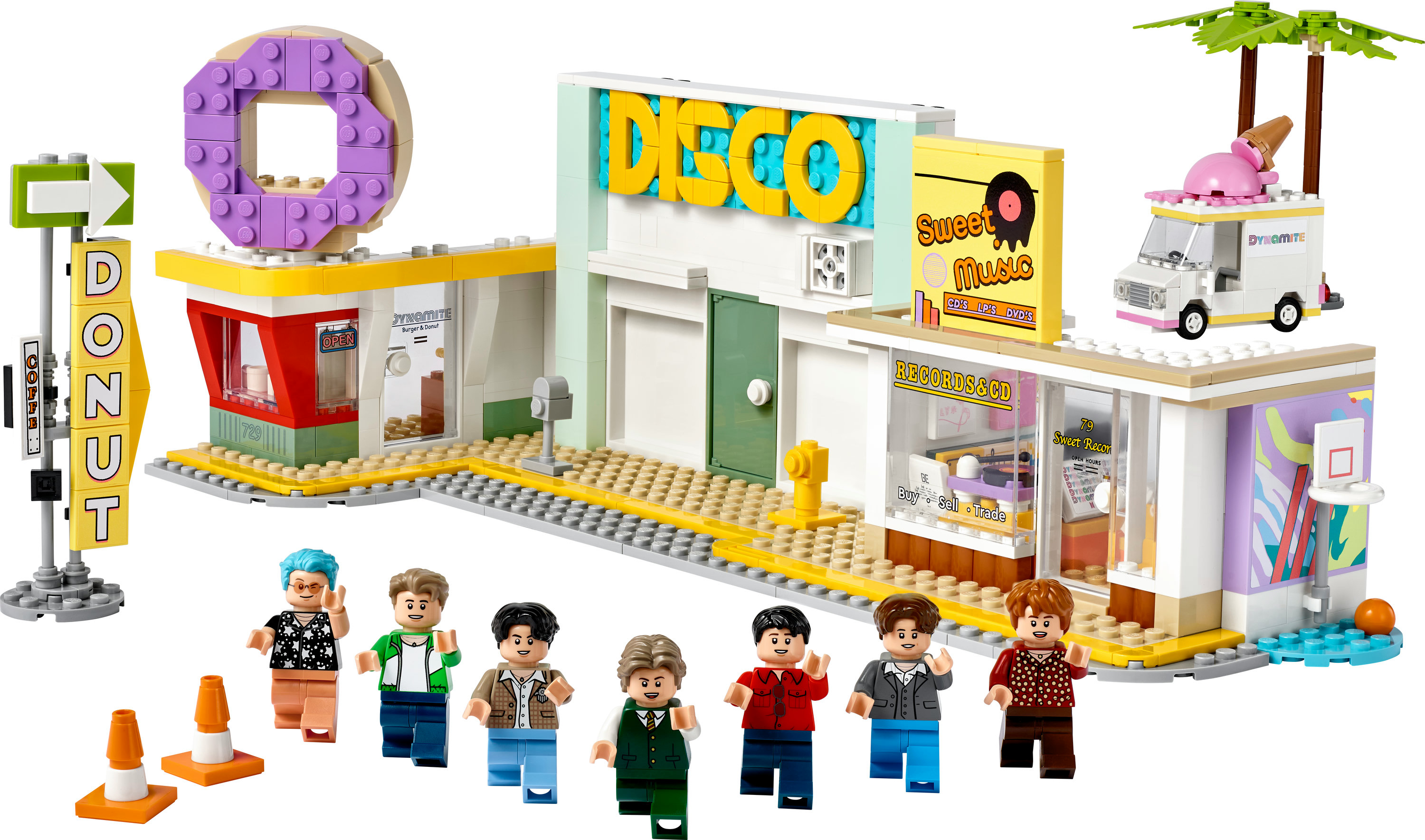 Beyaz bir arka plan üzerinde, mini figürler, bir donut dükkanı, bir disko ve bir minibüs bulunan bir LEGO seti.