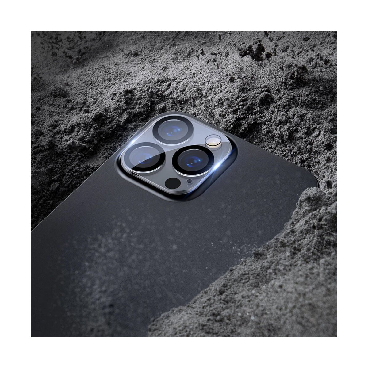 Telefono nero con lenti della fotocamera, con un proteggi-lenti trasparente su una superficie scura.