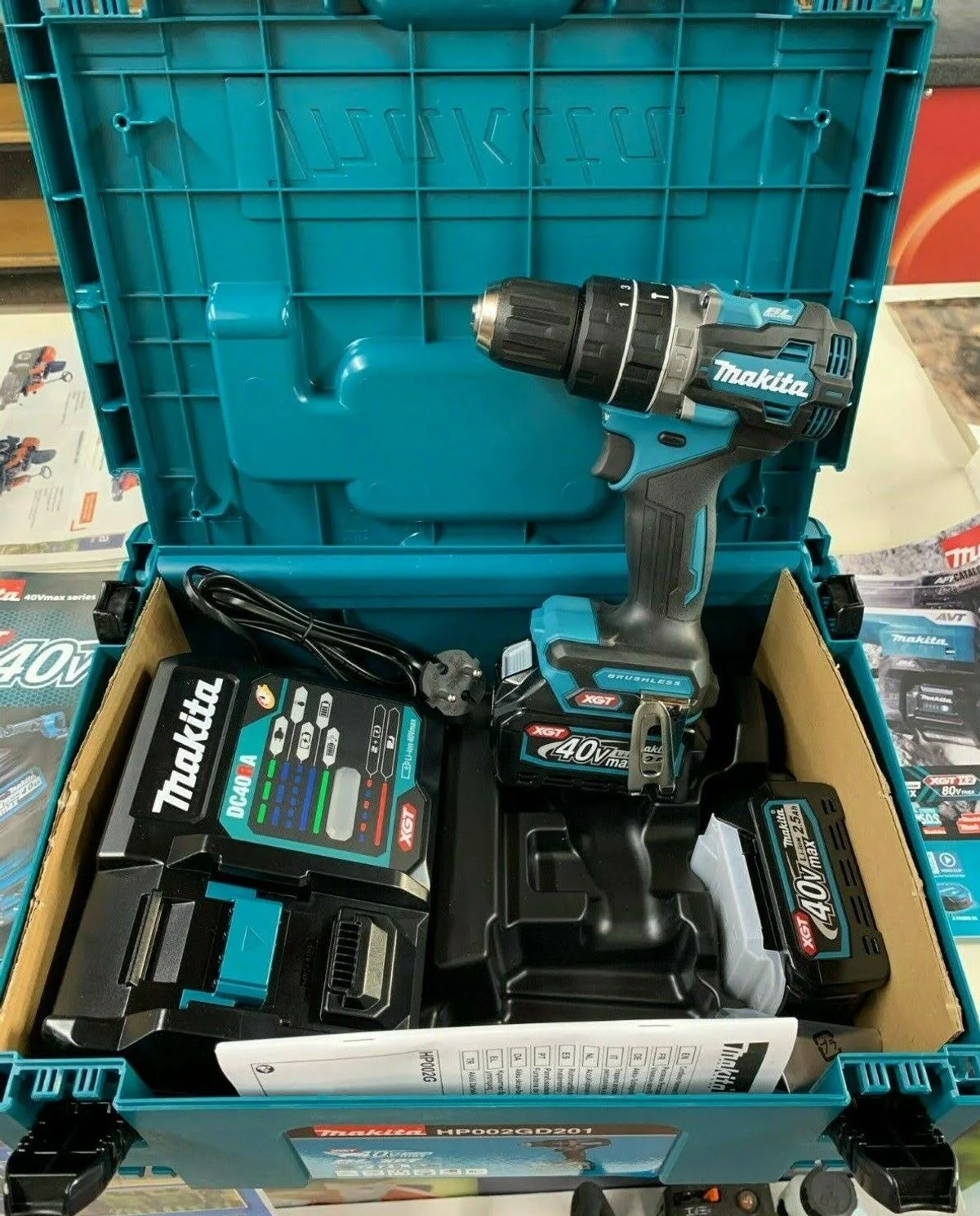 Taladro inalámbrico Makita en maleta turquesa, con batería y cargador.