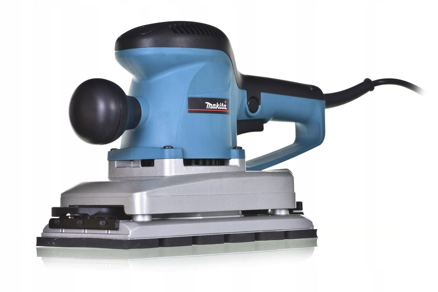 Lijadora Makita azul y negra sobre fondo blanco. Tiene un asa negra y una base rectangular.
