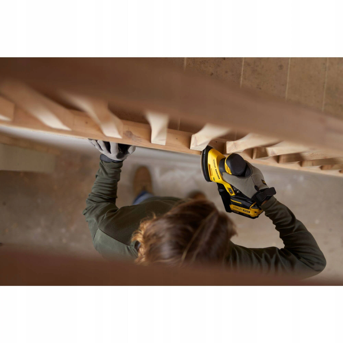 Persona lijando una escalera de madera, vista superior.