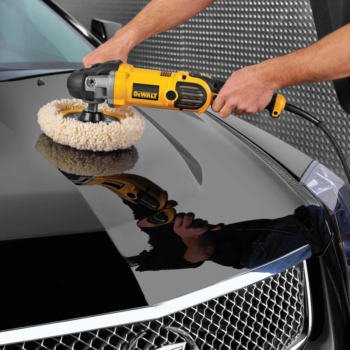Personne polissant une voiture noire avec une polisseuse DeWalt. Reflet sur la surface.