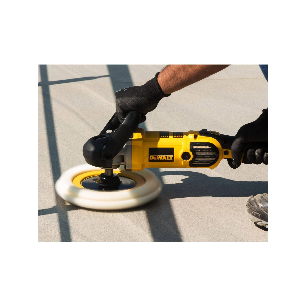 Personne utilisant une ponceuse électrique jaune sur une surface.