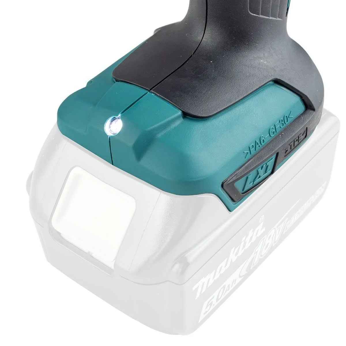 Primer plano de una herramienta eléctrica con carcasa verde y negra. Una luz brilla desde el frente.