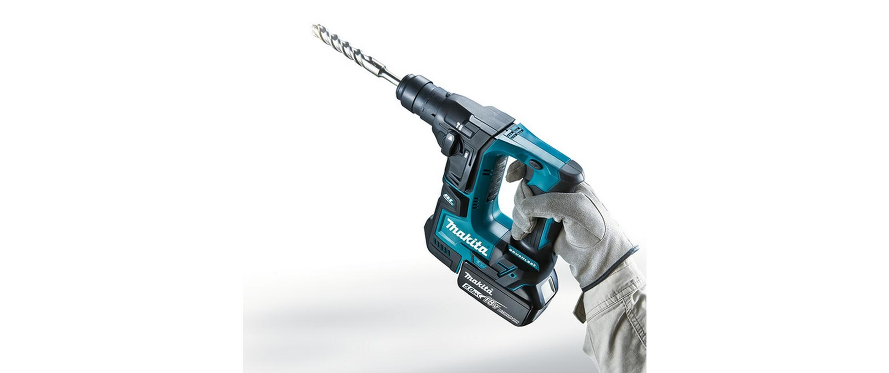 Eine kabellose Makita-Bohrmaschine mit einem Bohrer, gehalten von einer behandschuhten Hand, vor weißem Hintergrund.