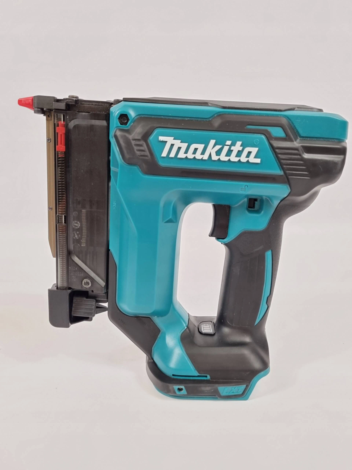 Una pistola de clavos Makita turquesa. Detalles negros, con boquilla roja, sobre fondo blanco.