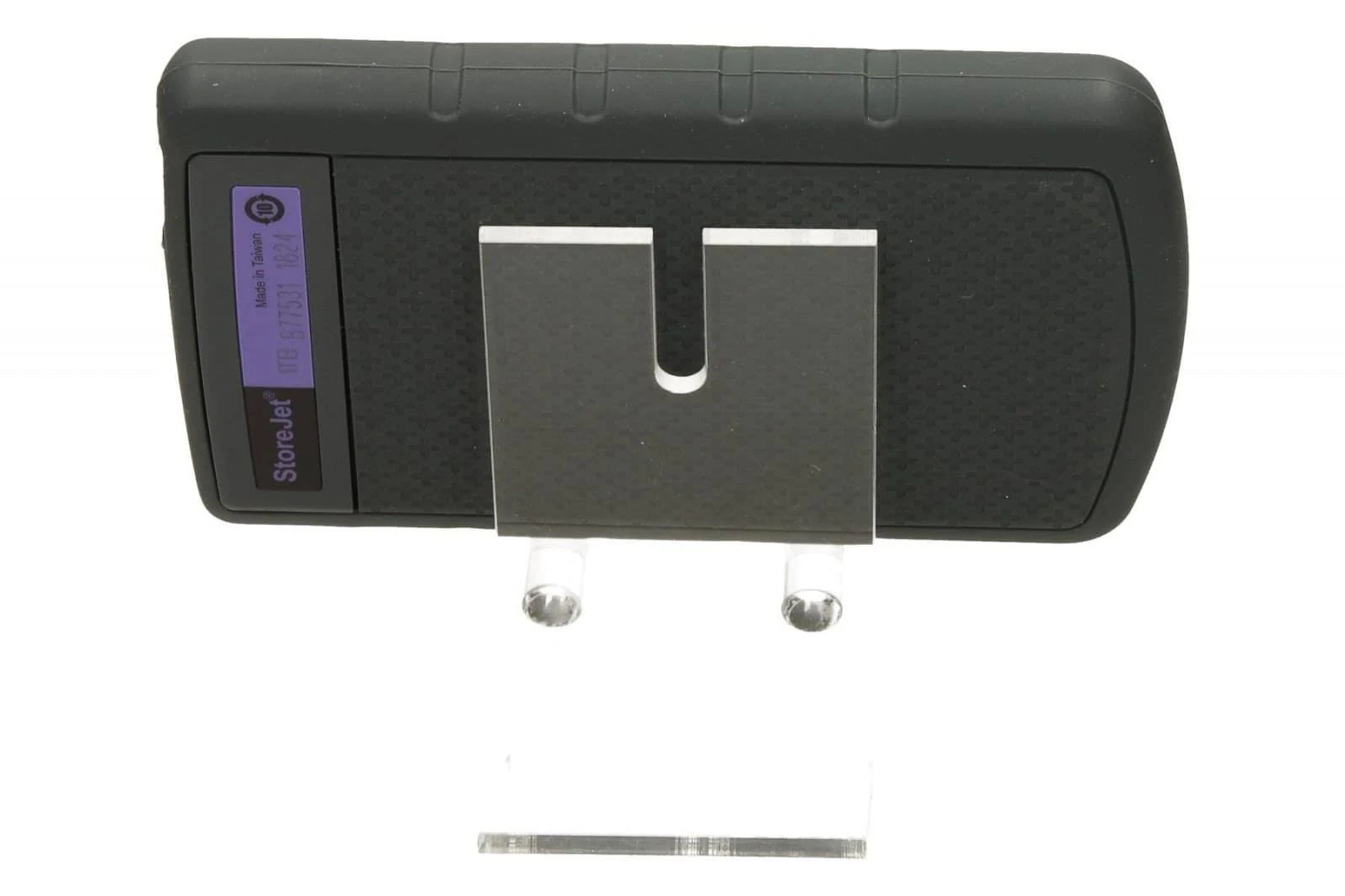 Czarny przenośny dysk twardy na przezroczystym plastikowym stojaku, widok z góry na białym tle.