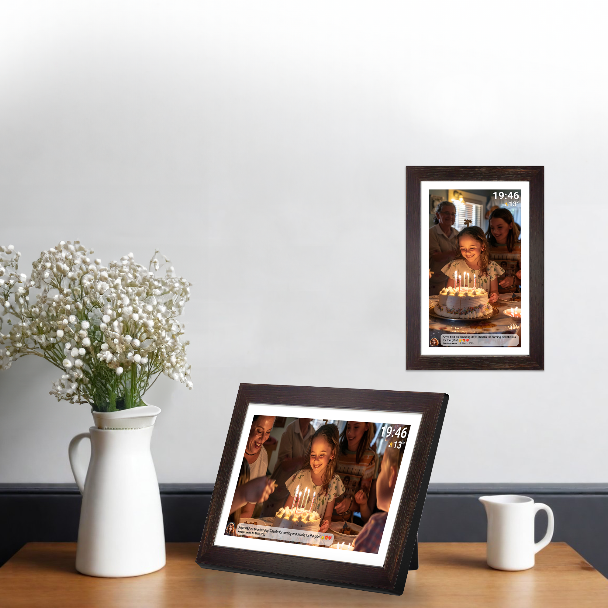 Deux cadres photo numériques sur une table, montrant une fête d'anniversaire. Vase blanc.