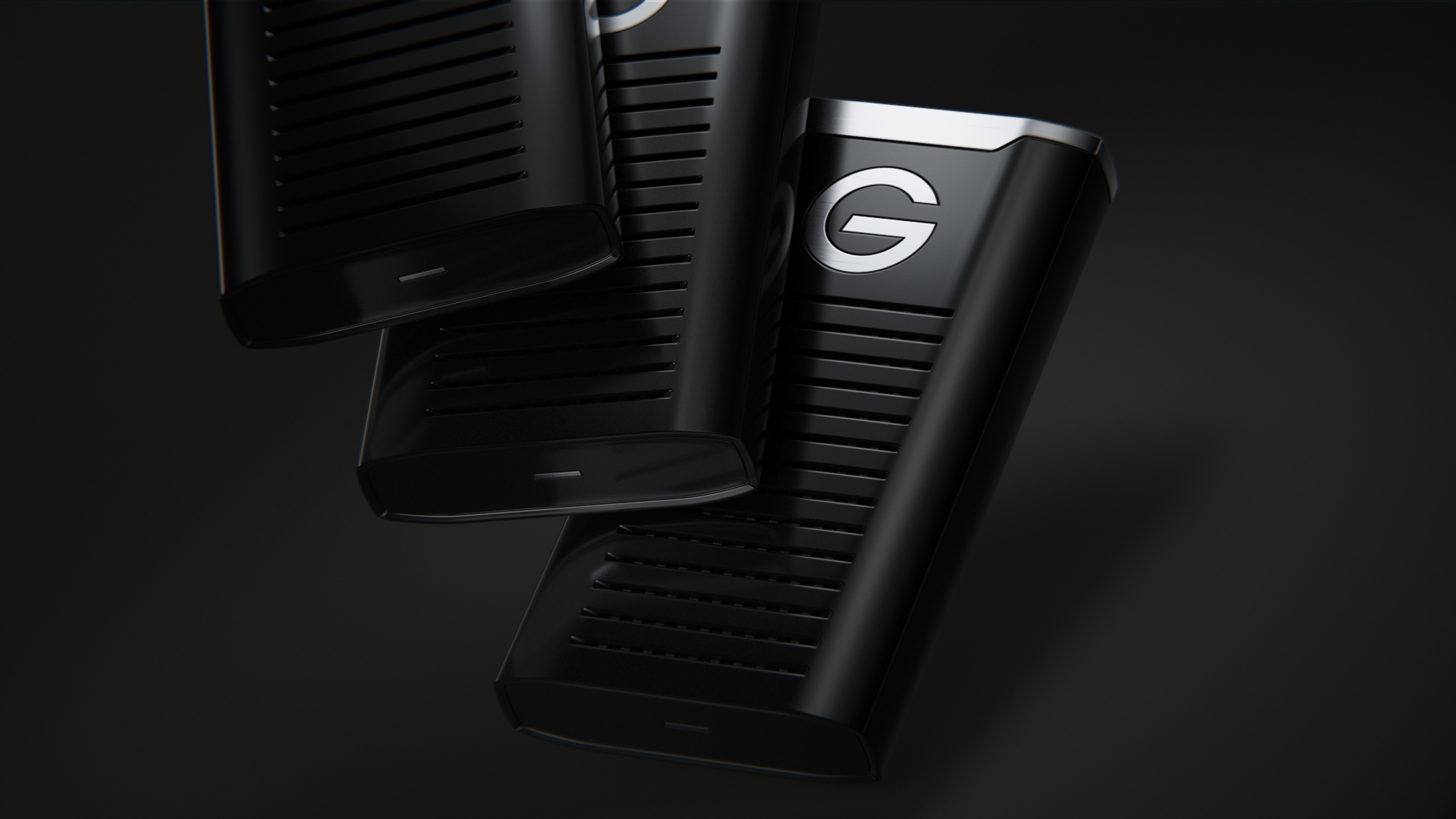 Czarne urządzenie do przechowywania danych. Trzy jednostki, czarne, logo G, pod kątem na ciemnym tle.