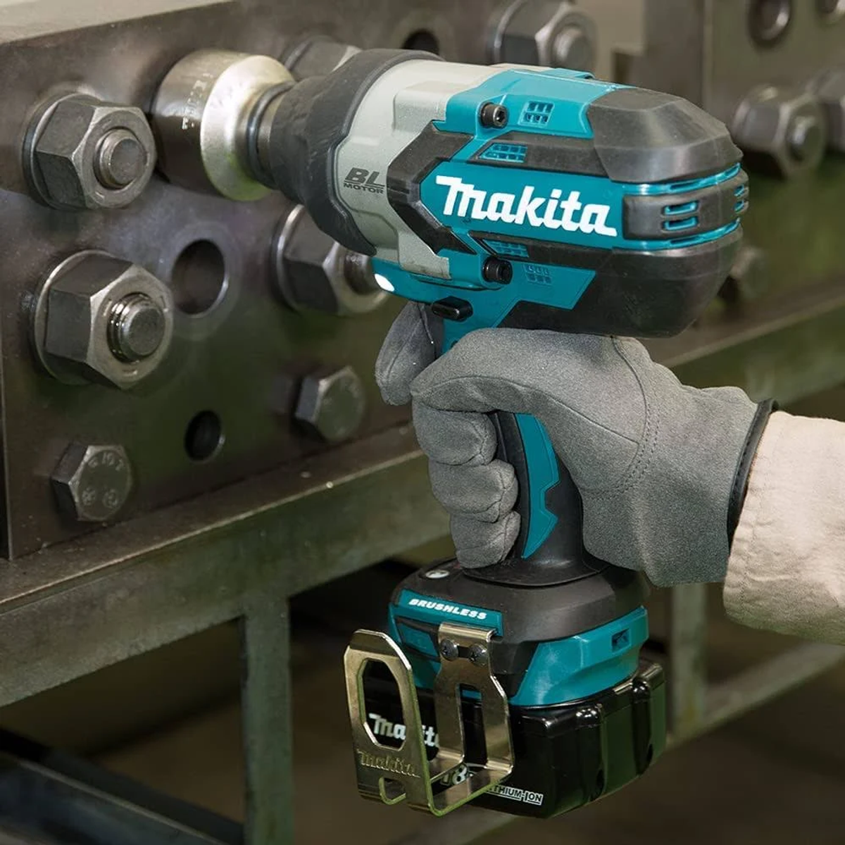 Robotnik używa turkusowego klucza udarowego Makita na metalowej śrubie. Narzędzie ma czarny akumulator.