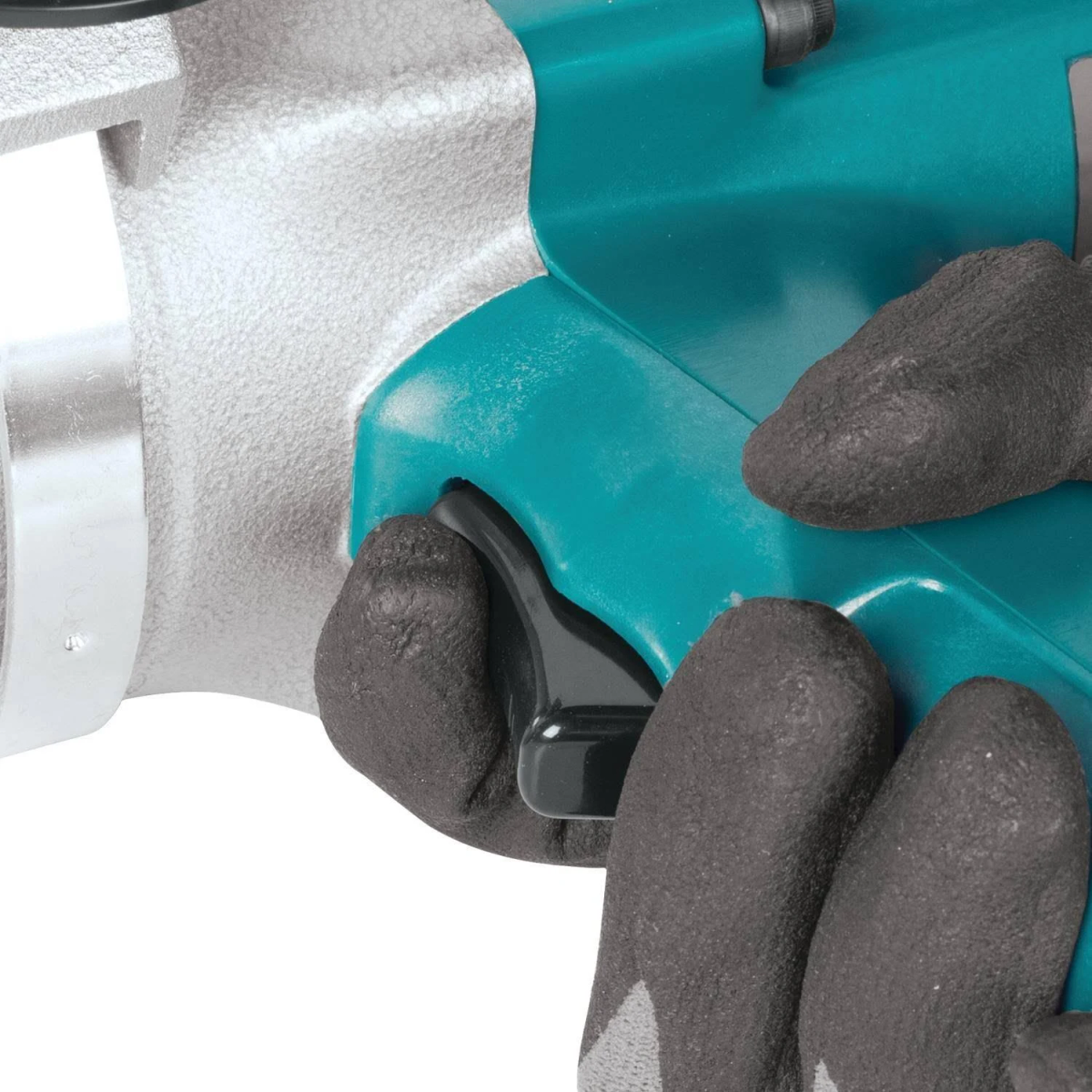 Primo piano di mani con guanti neri, che azionano un utensile color verde acqua. Sfondo bianco, parte dell'utensile è visibile.