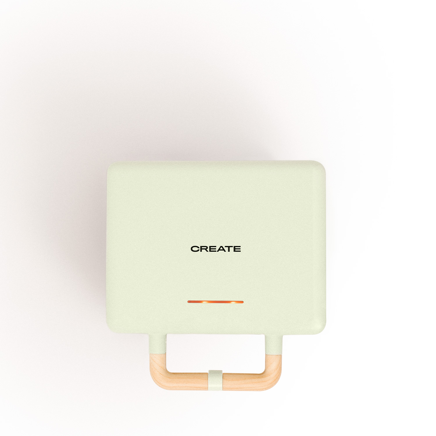 Una parrilla eléctrica verde menta con mango de madera, la palabra 'CREATE' en la parte frontal.