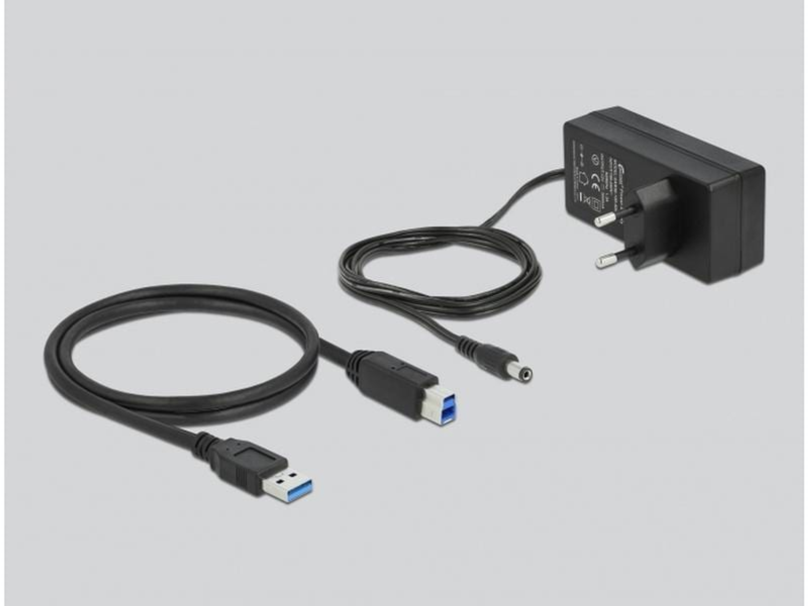 Schwarzes USB-Kabel, USB-C-Anschluss und Netzteil auf grauem Hintergrund.
