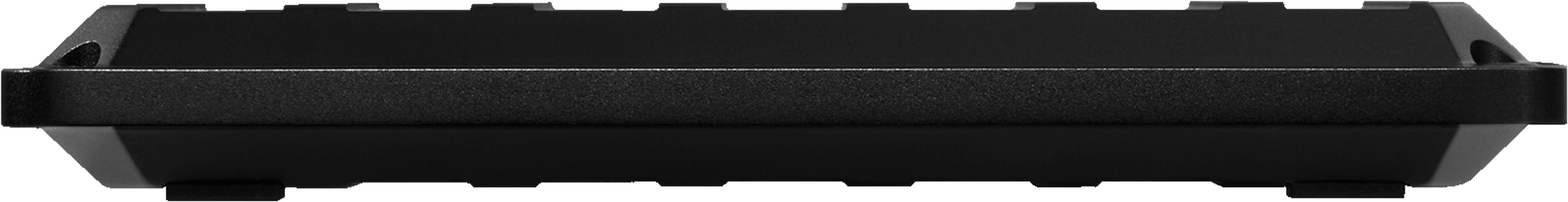 Spód czarnej plastikowej klawiatury. Ma żebrowaną teksturę i gumowe nóżki. Izolowany na czarnym tle.