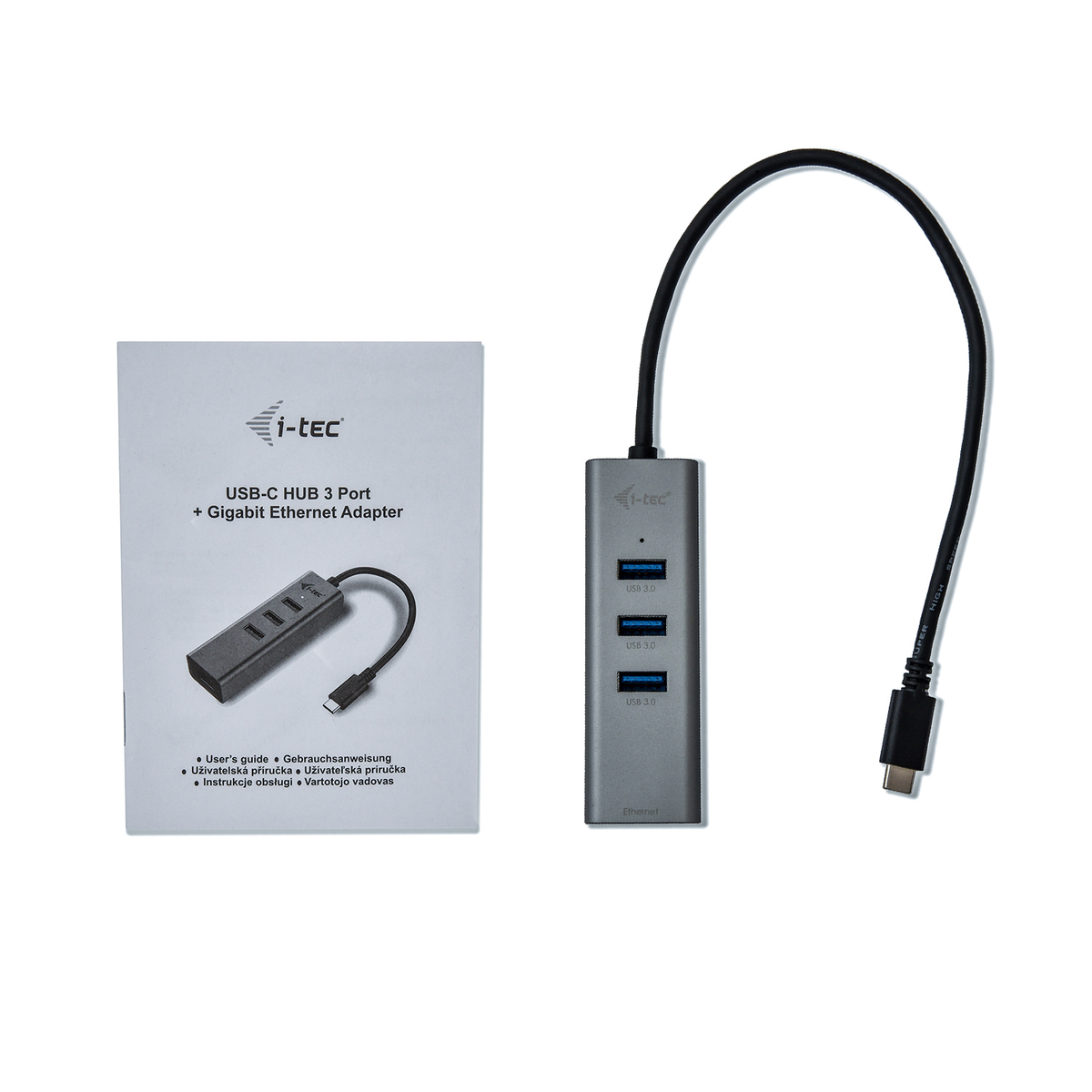 Un hub USB-C et un manuel. Le hub est gris et possède trois ports USB. Le manuel est blanc.