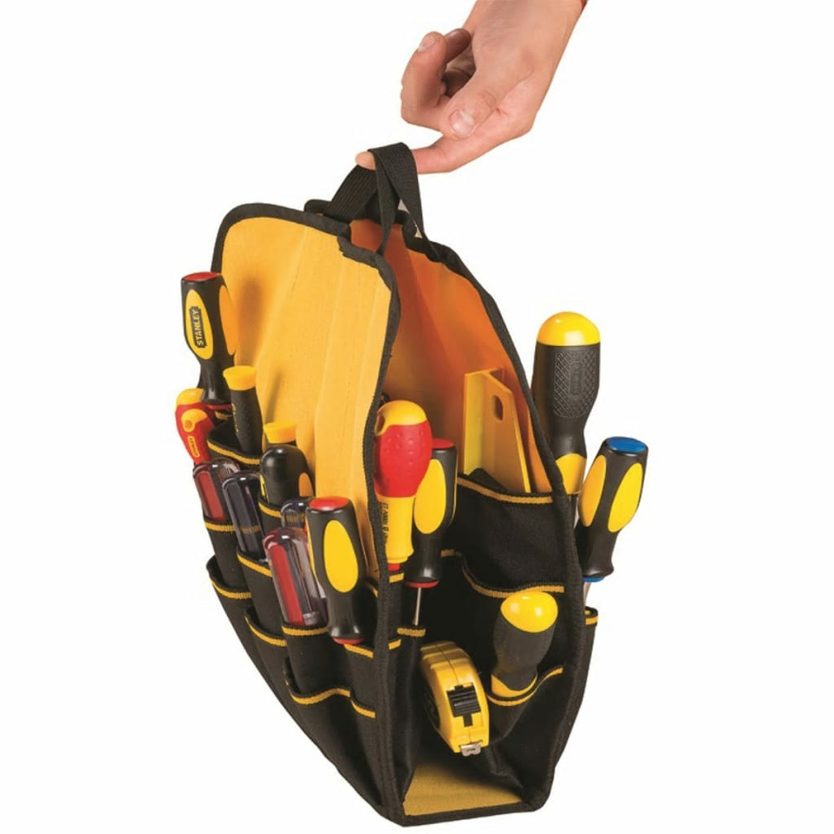 Una mano tiene una borsa degli attrezzi nera e gialla piena di cacciaviti e un metro a nastro.