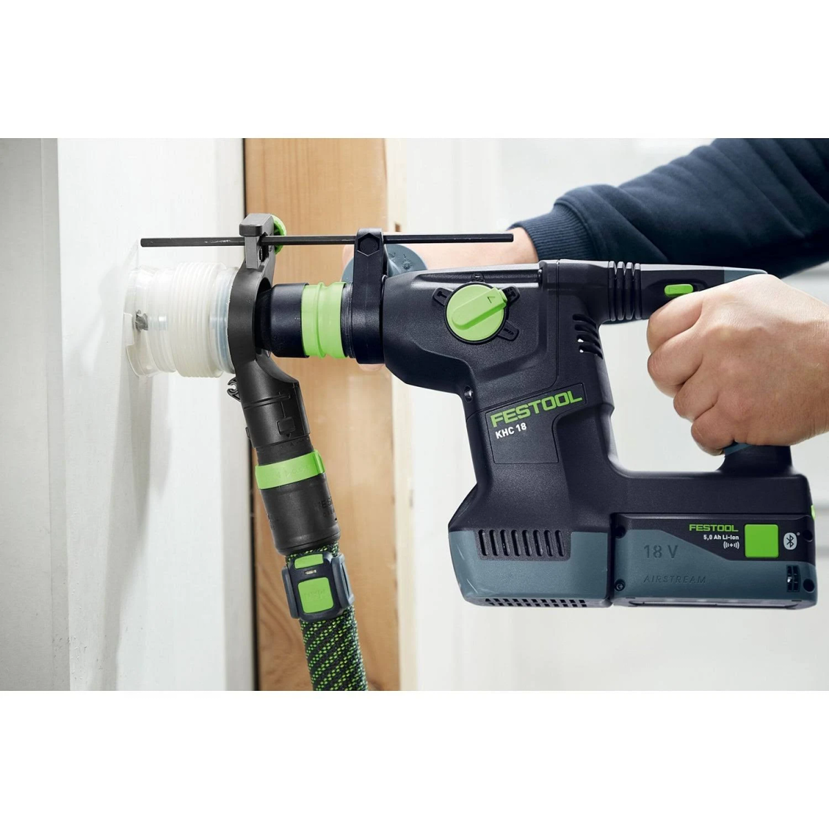 Una persona taladrando una pared con un martillo perforador Festool.