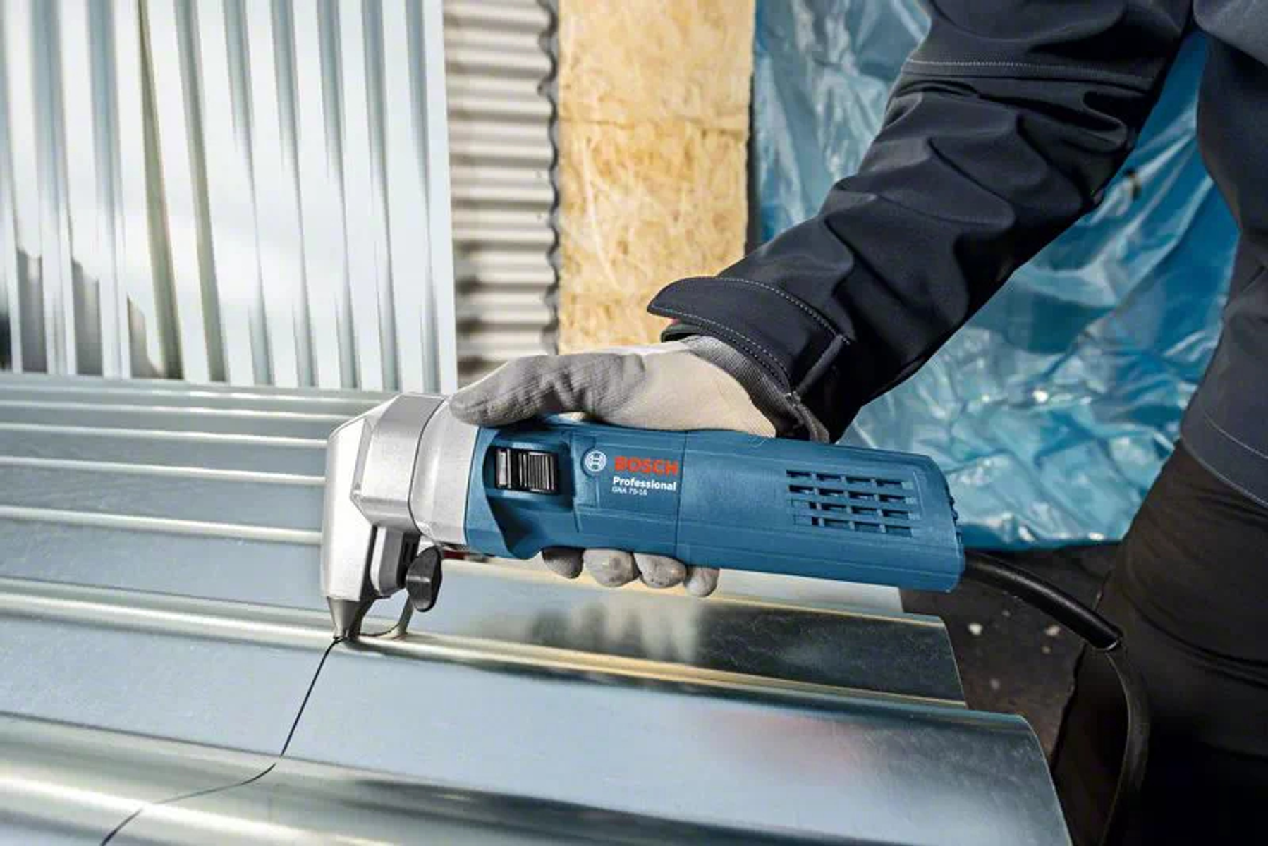 Utensile Bosch blu e grigio che taglia il metallo. Persona con guanti grigi che tiene in mano l'utensile.