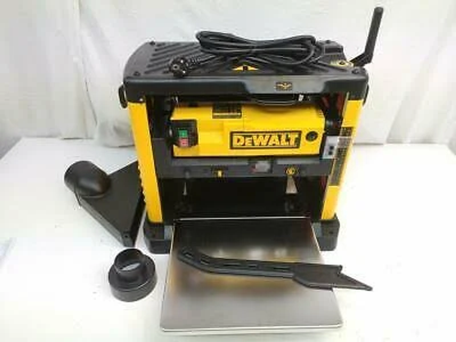 Żółto-czarna strugarka DeWalt. Zawiera odkurzacz, osłonę ostrza i metalowy stół roboczy.