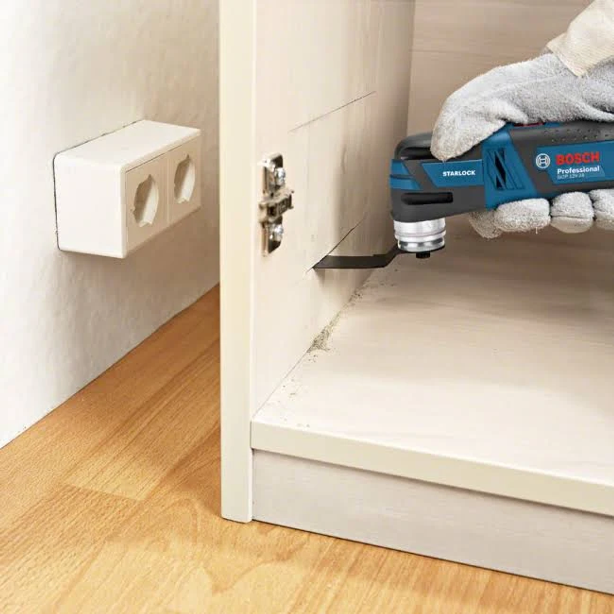 Una persona usa una herramienta Bosch Starlock para cortar un armario.