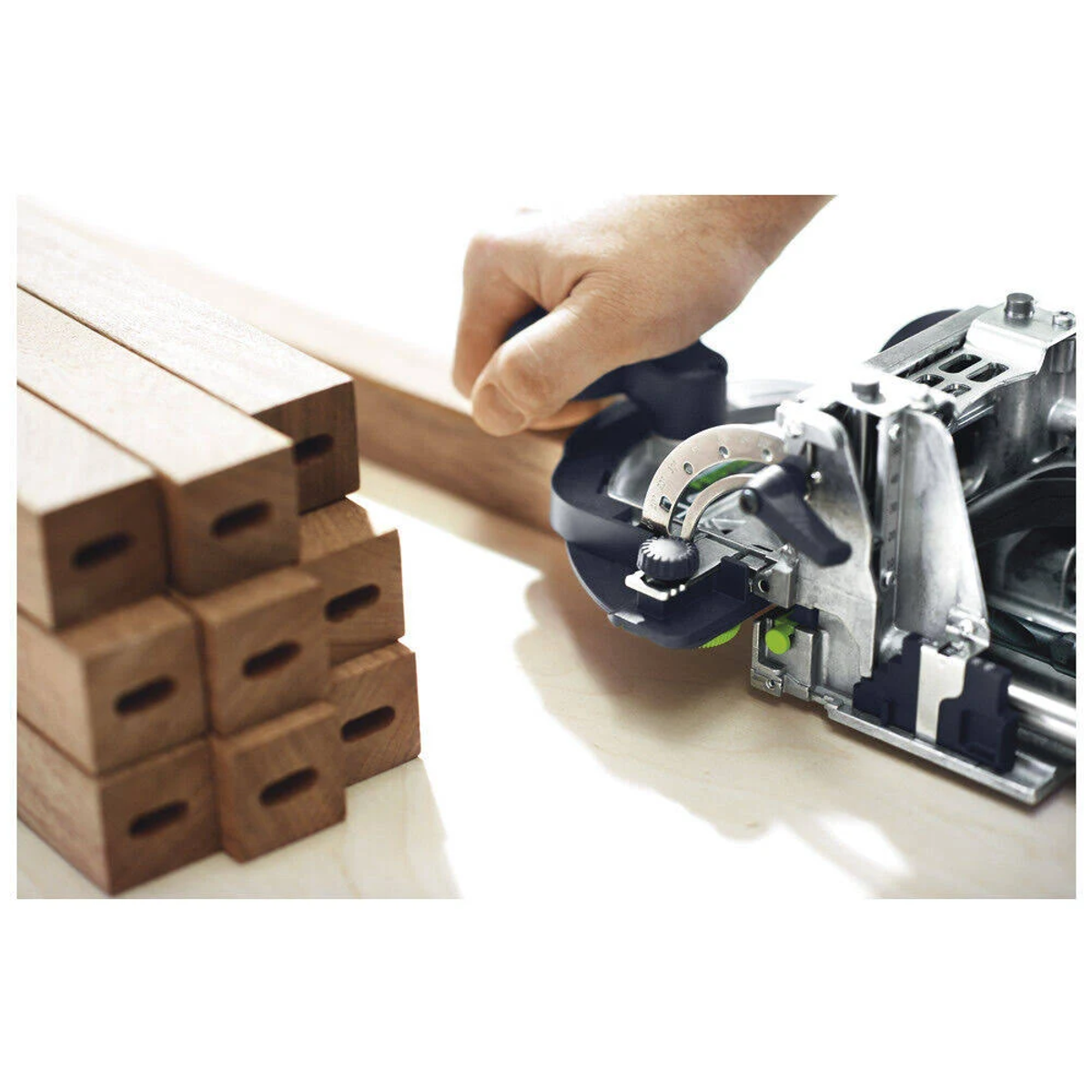 La mano di una persona guida un utensile per la lavorazione del legno su blocchi di legno.