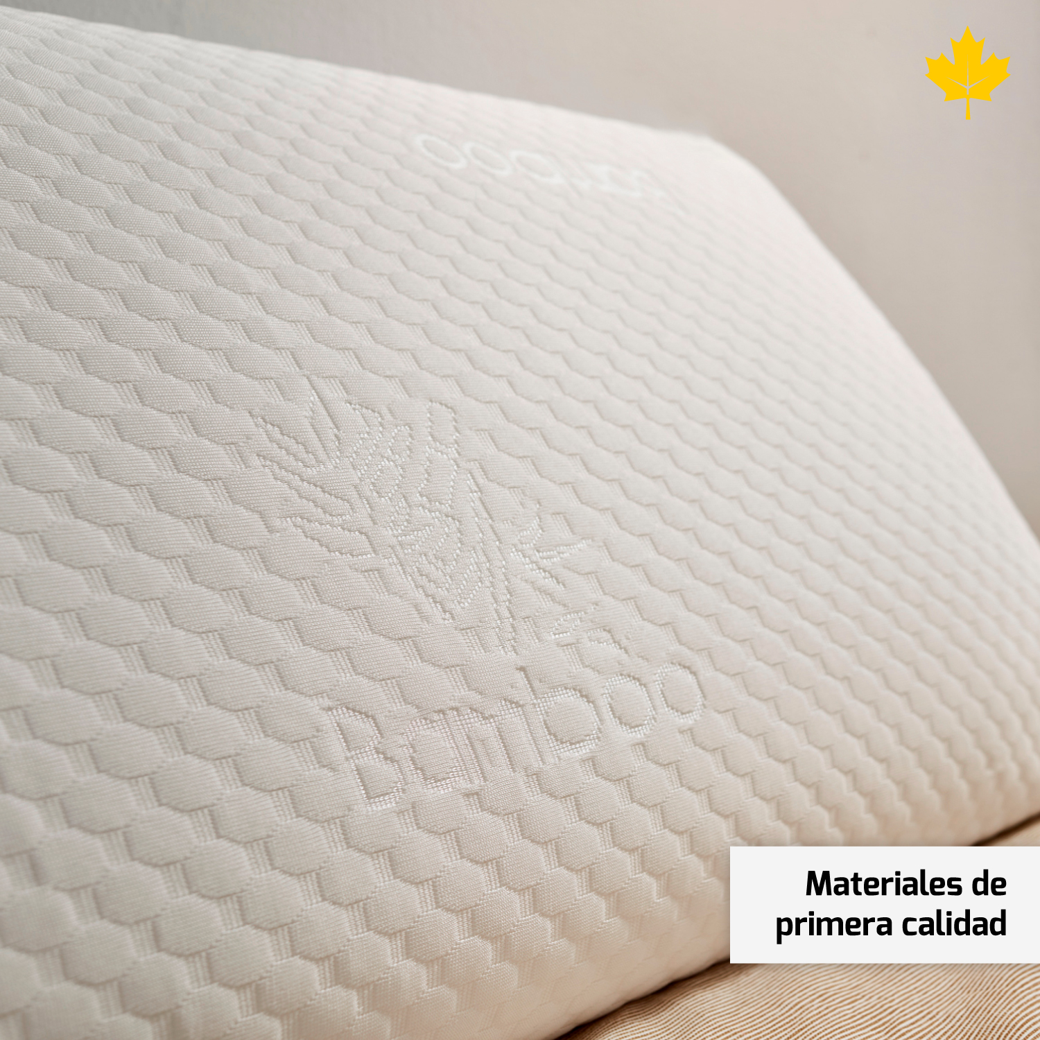 Primer plano de una almohada blanca con un logotipo de bambú. La almohada está en una cama con una sábana marrón claro y una etiqueta de texto.