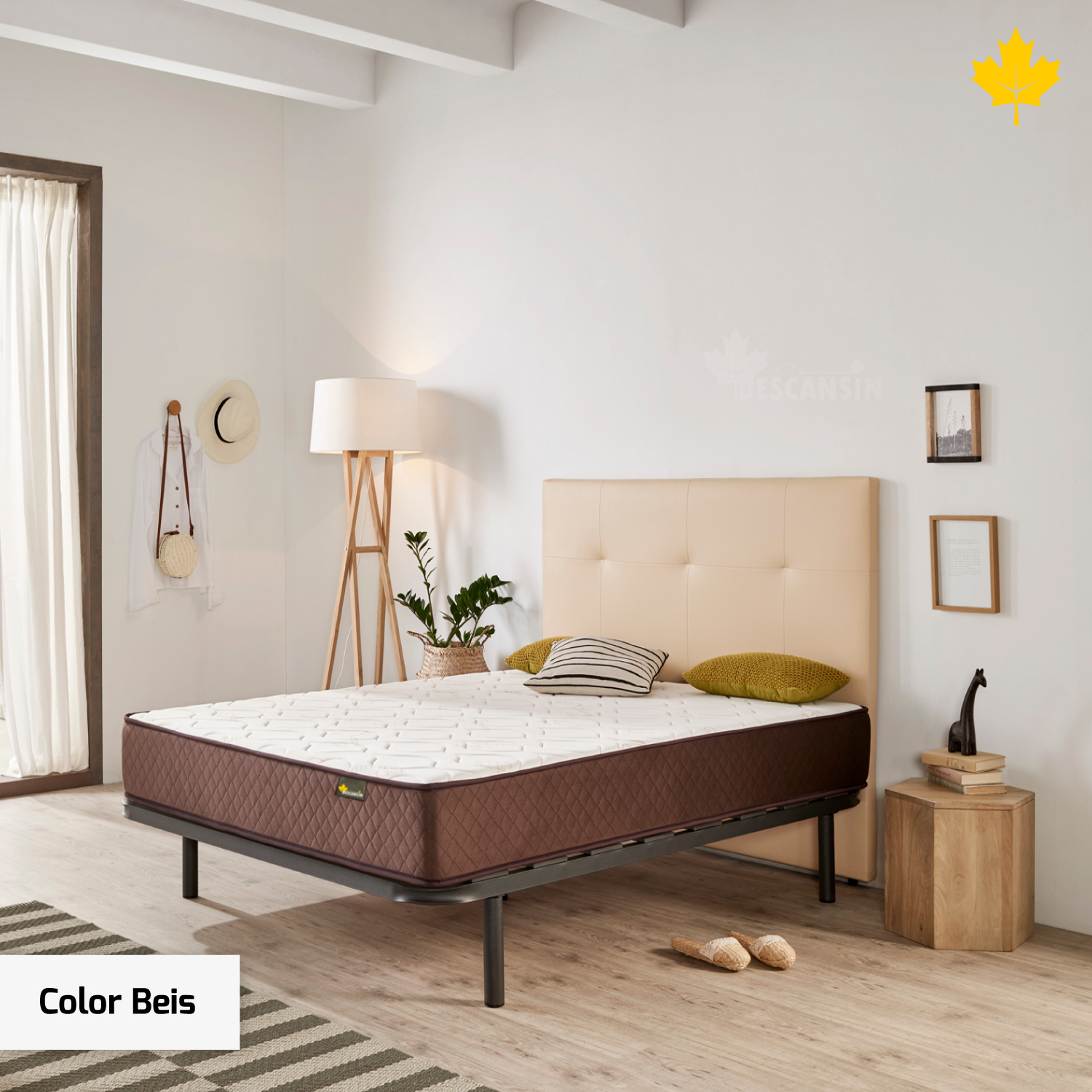 Dormitorio con cabecero beige y colchón marrón. Mesita de noche de madera, lámpara y alfombra a rayas.