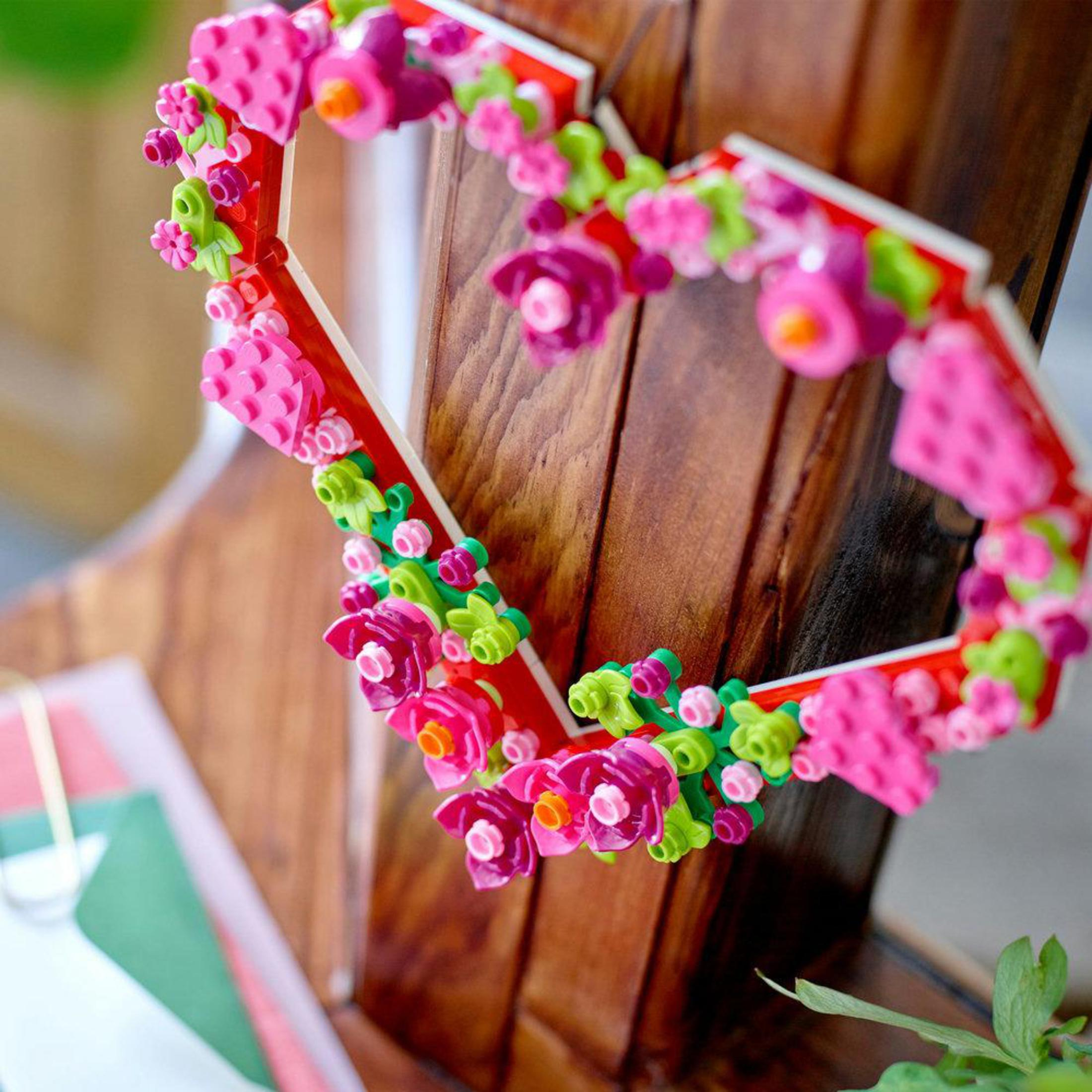 Ozdoba Lego w kształcie serca z kwiatami. Drewniane tło.