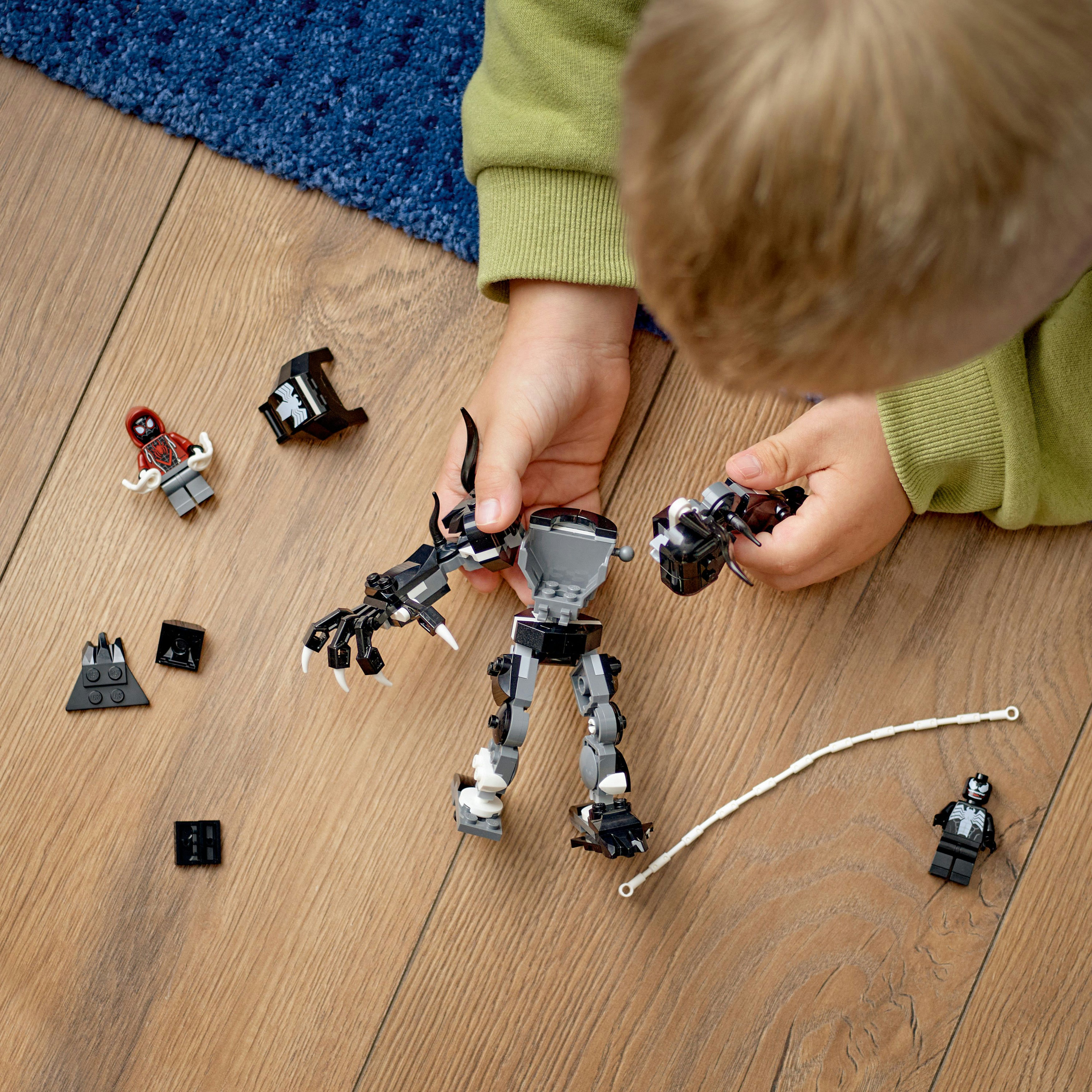 Kind spielt mit Lego-Figuren. Lego Venom-Figur. Lego Spider-Man-Figur.