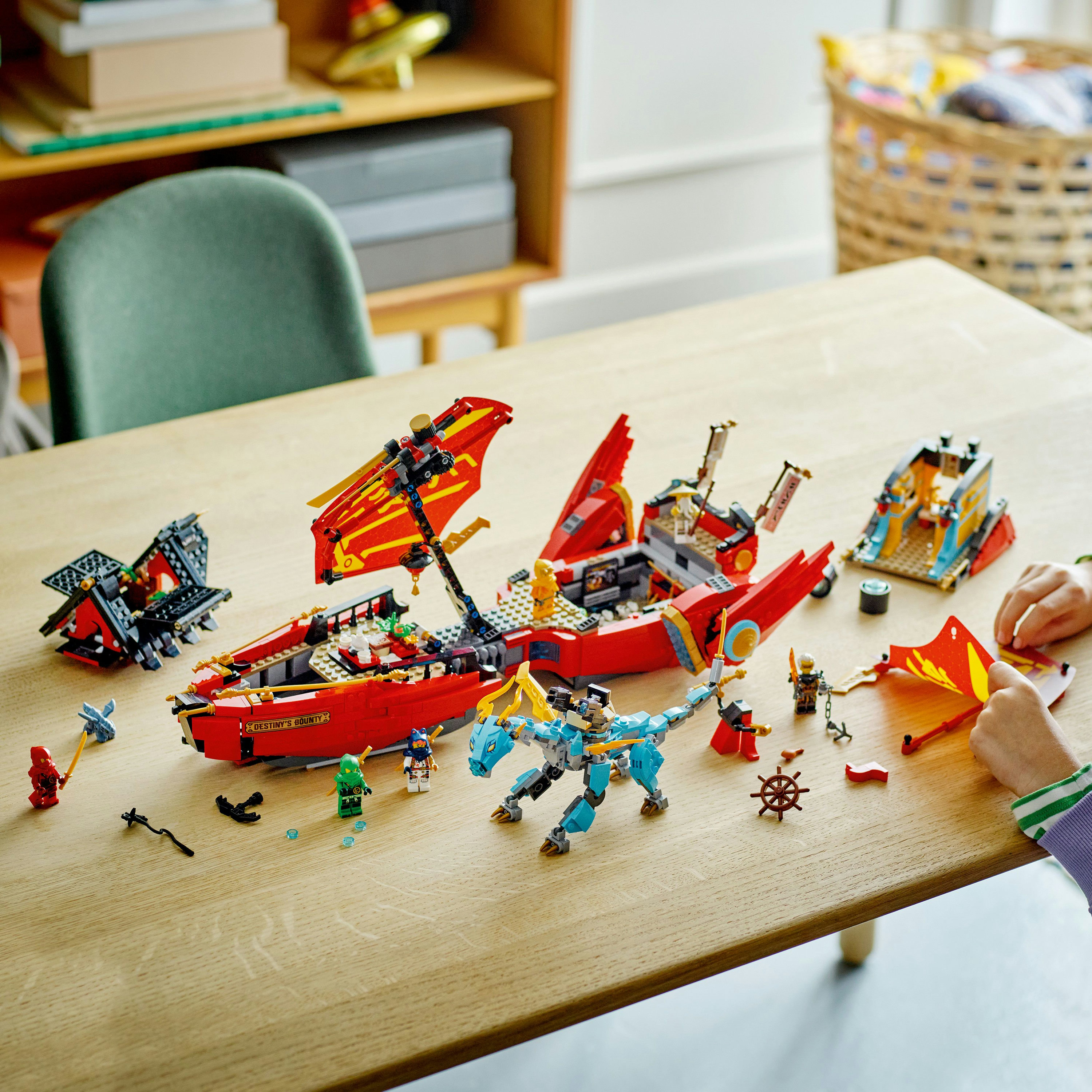 Set Lego Ninjago. Barca rossa con personaggi su tavolo di legno. Personaggi e accessori Lego.