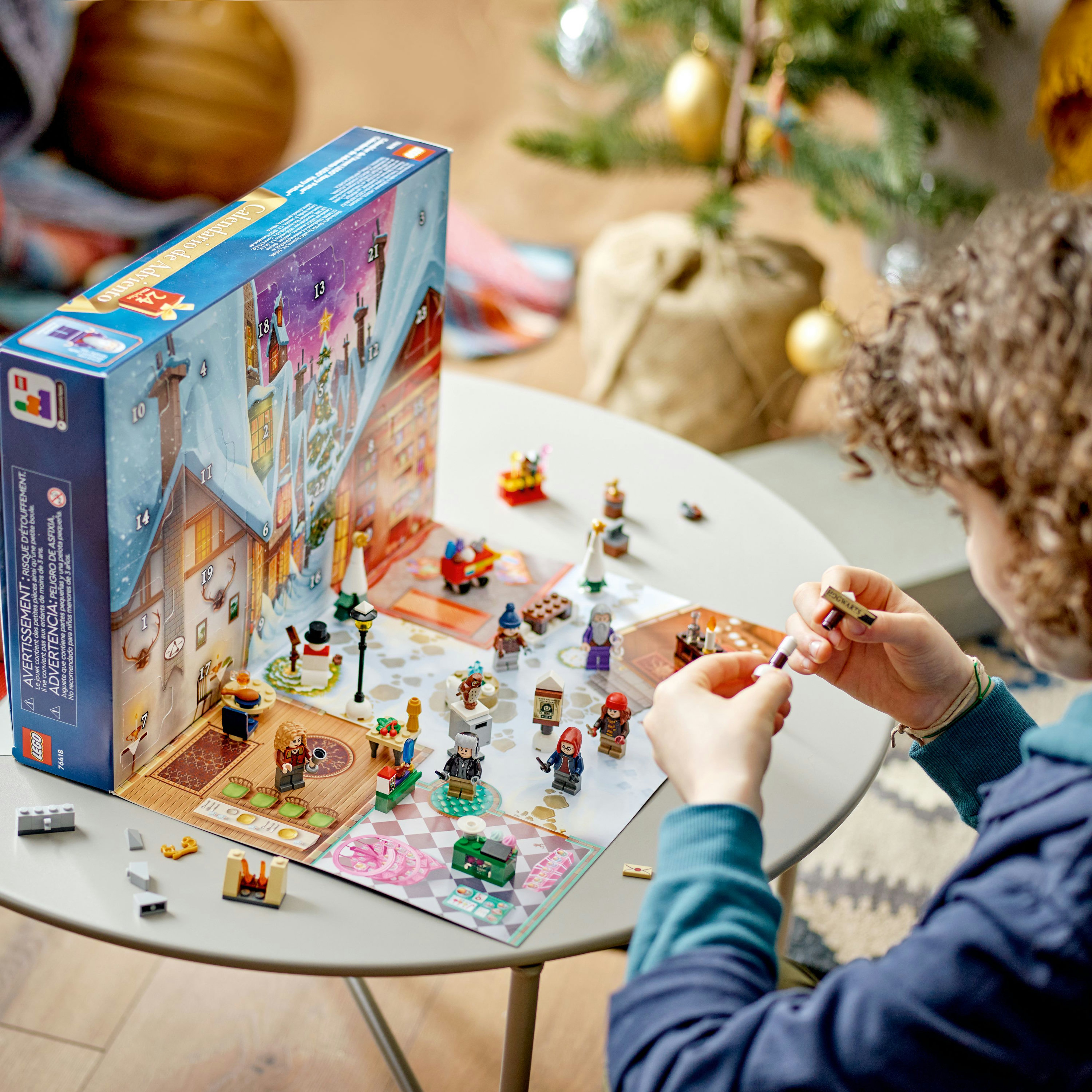 Una persona che assembla pezzi Lego con un calendario dell'Avvento a tema natalizio sullo sfondo.