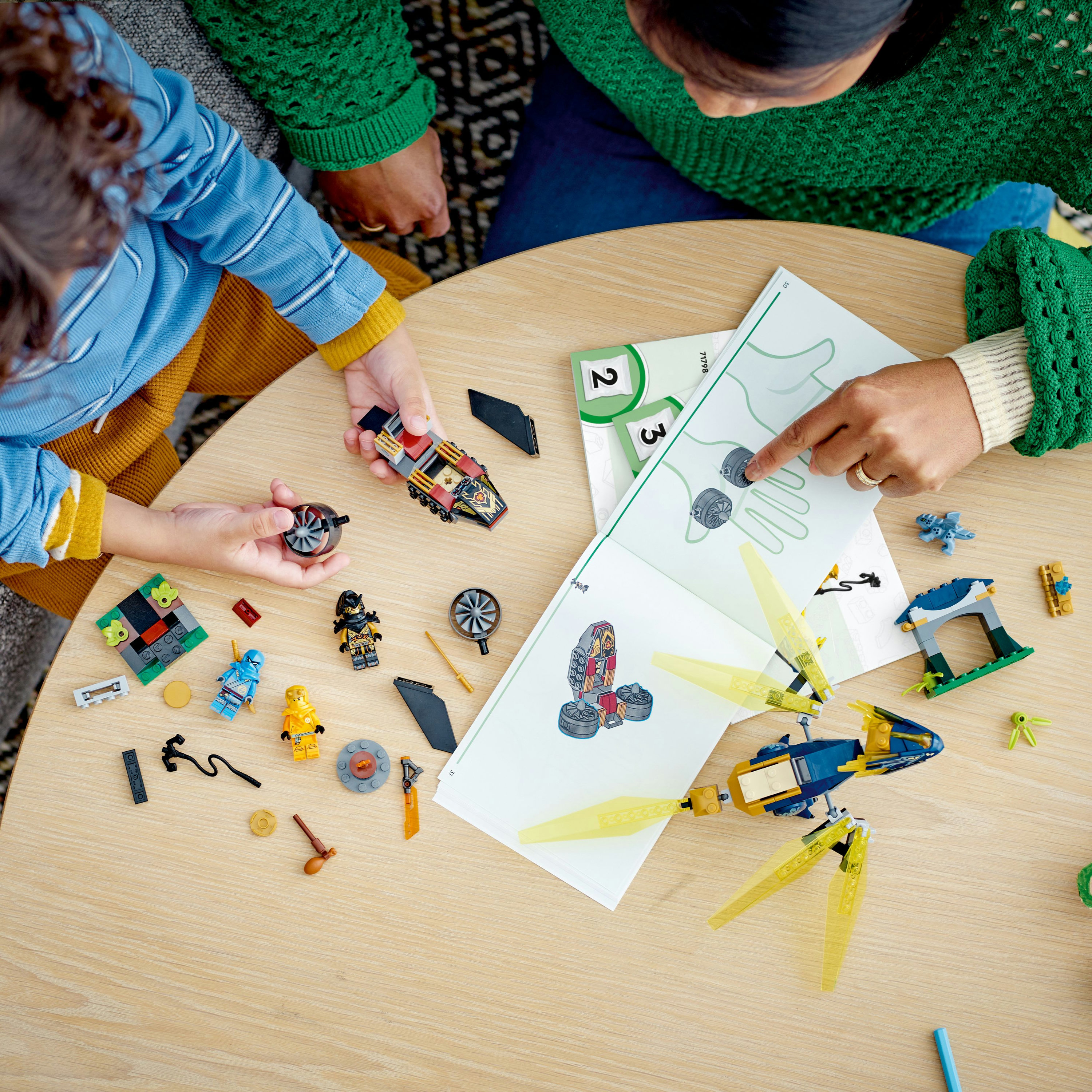 Dziecko i dorosły budują Lego na stole.