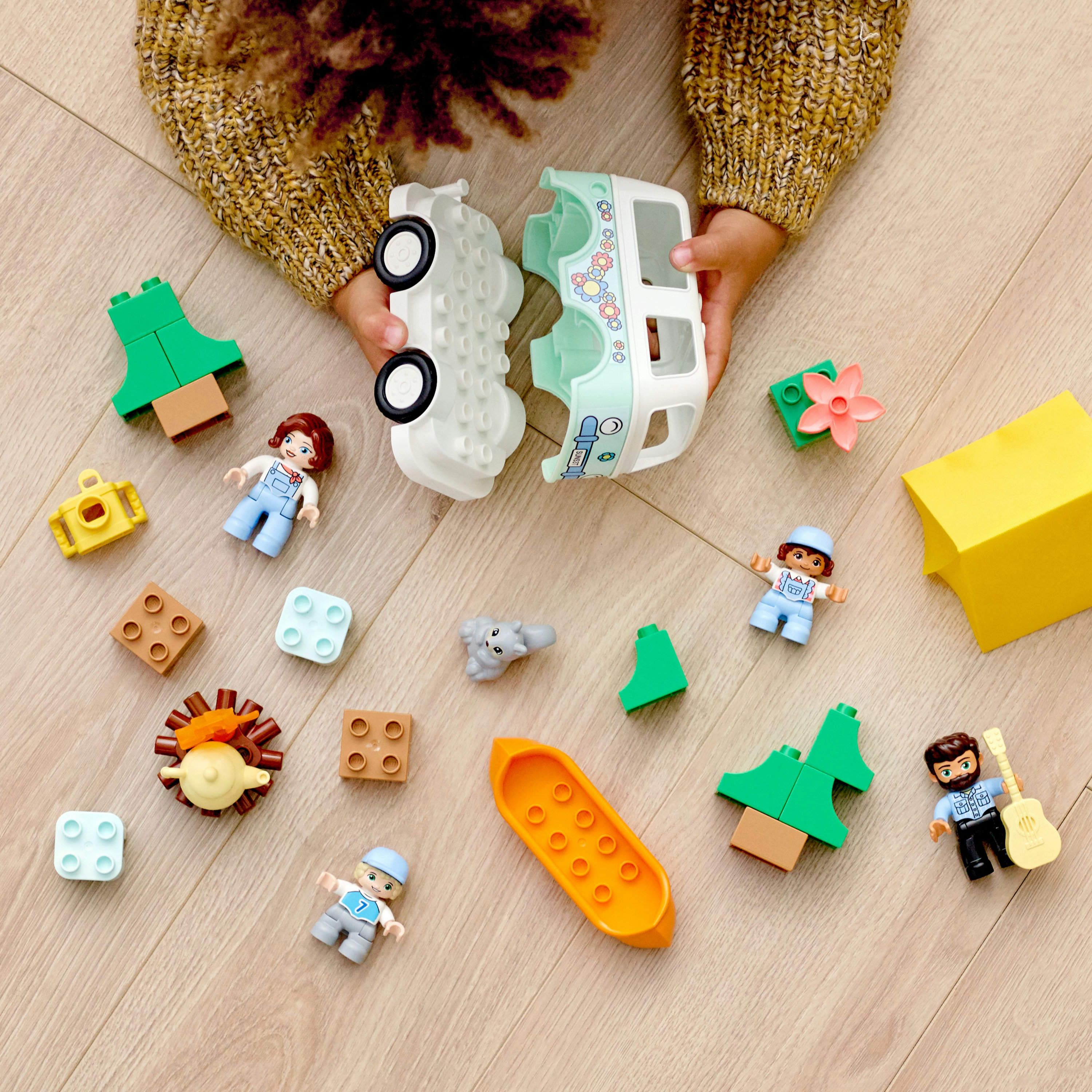 Una varietà di blocchi e personaggi Lego Duplo sparsi su un pavimento di legno.