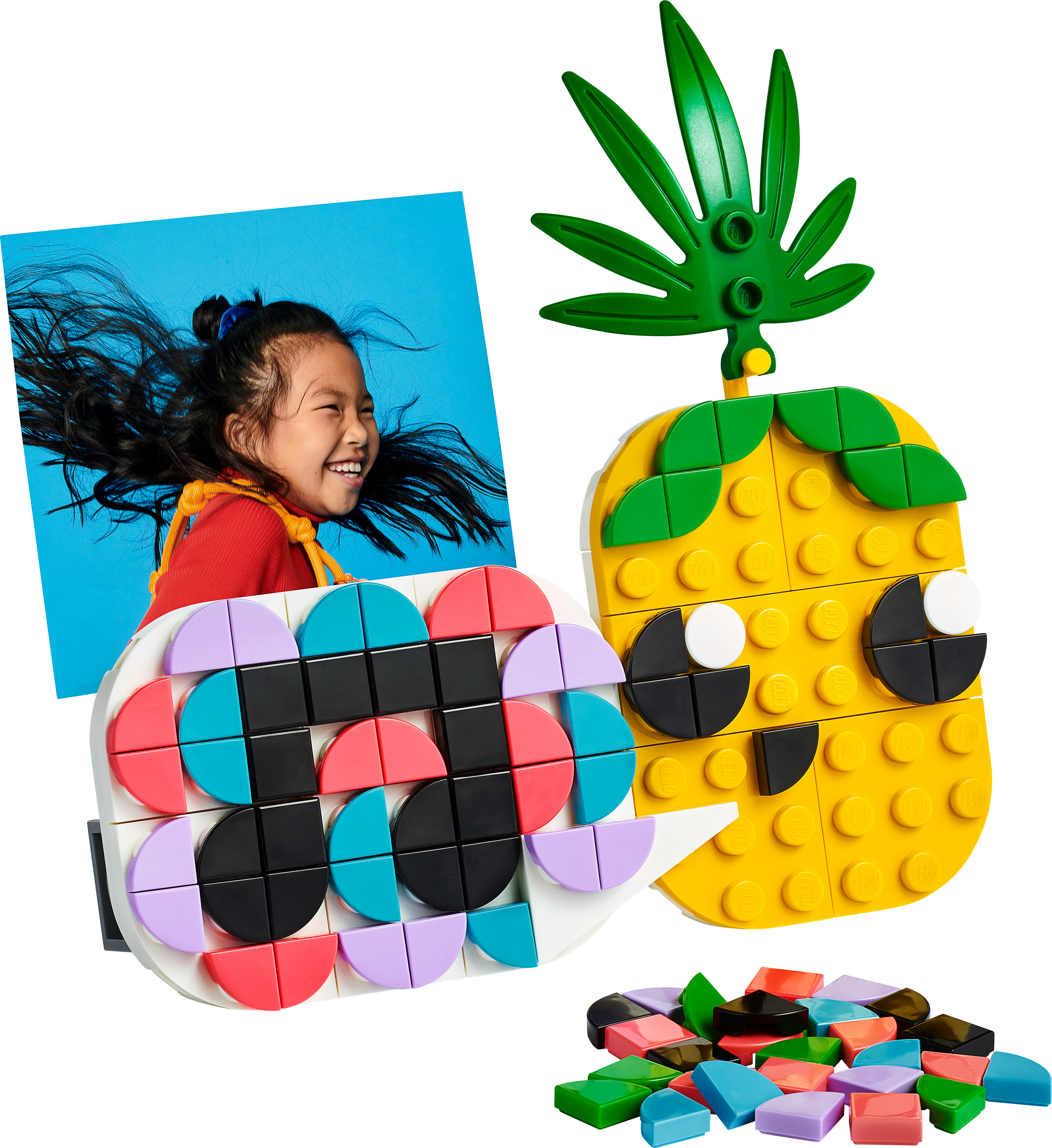Set Lego con una ragazza sorridente, un ananas e forme geometriche colorate. La ragazza ha i capelli lunghi.