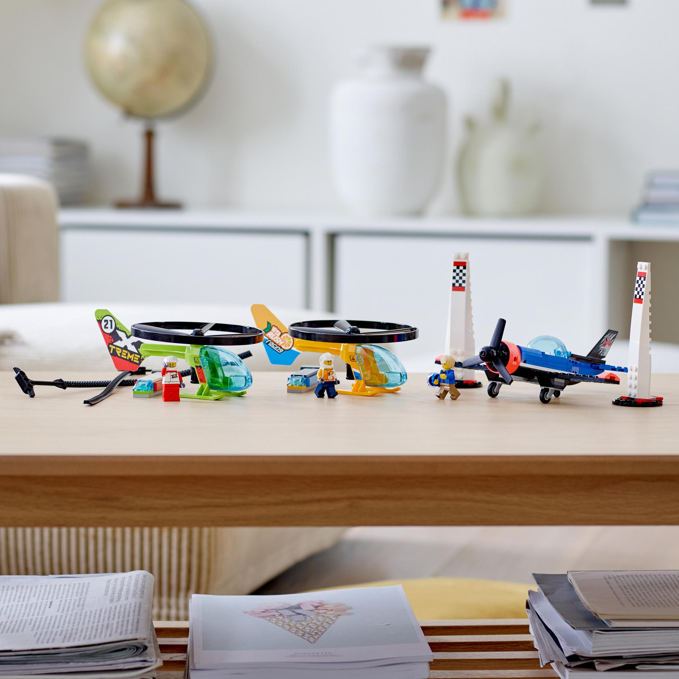 LEGO Flugzeug-Sets auf einem Holztisch, mit Büchern und Globus im Hintergrund.