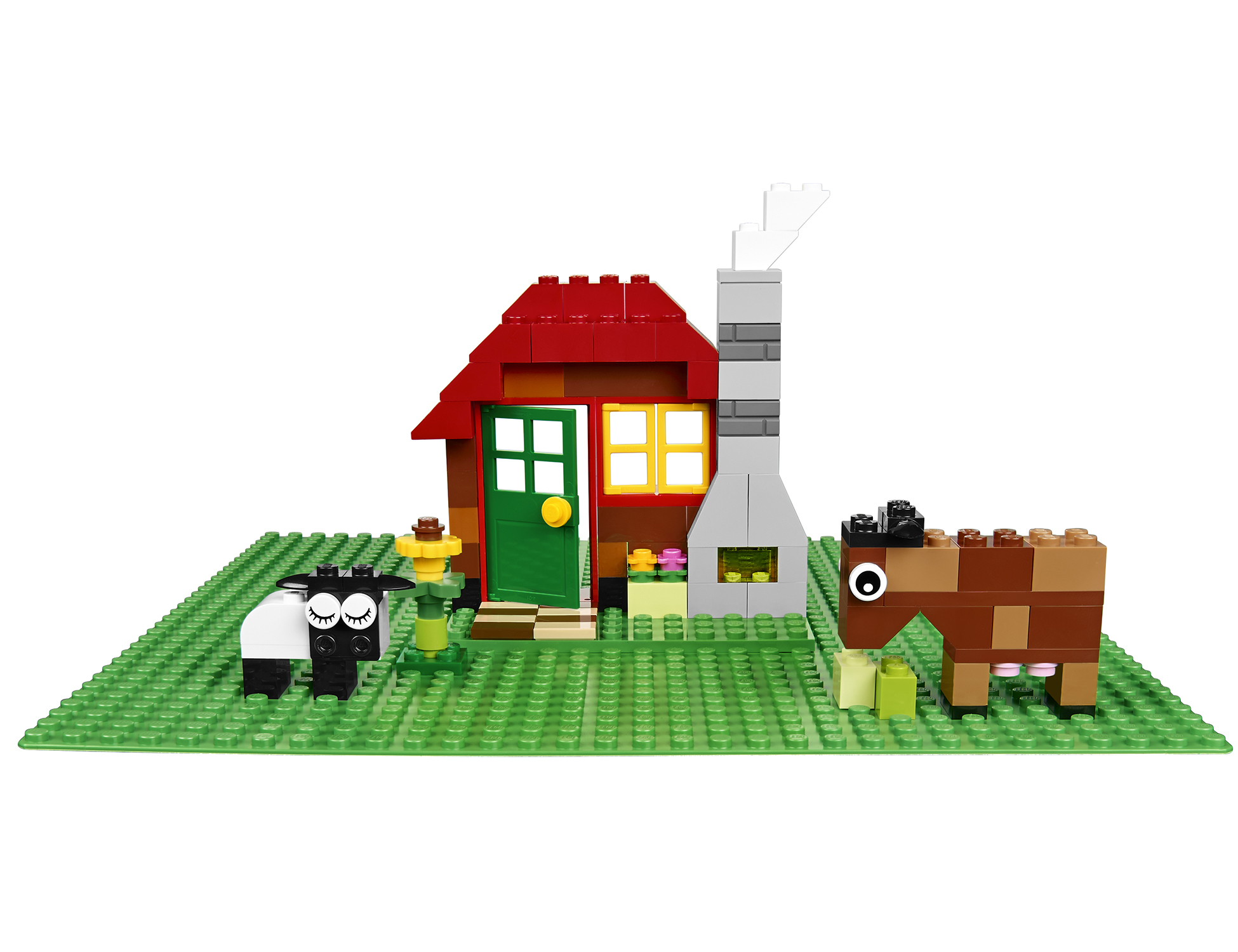 Lego-Hausszene mit rotem Dach, grüner Grundplatte, einem Schaf und einem Pferd auf weißem Hintergrund.