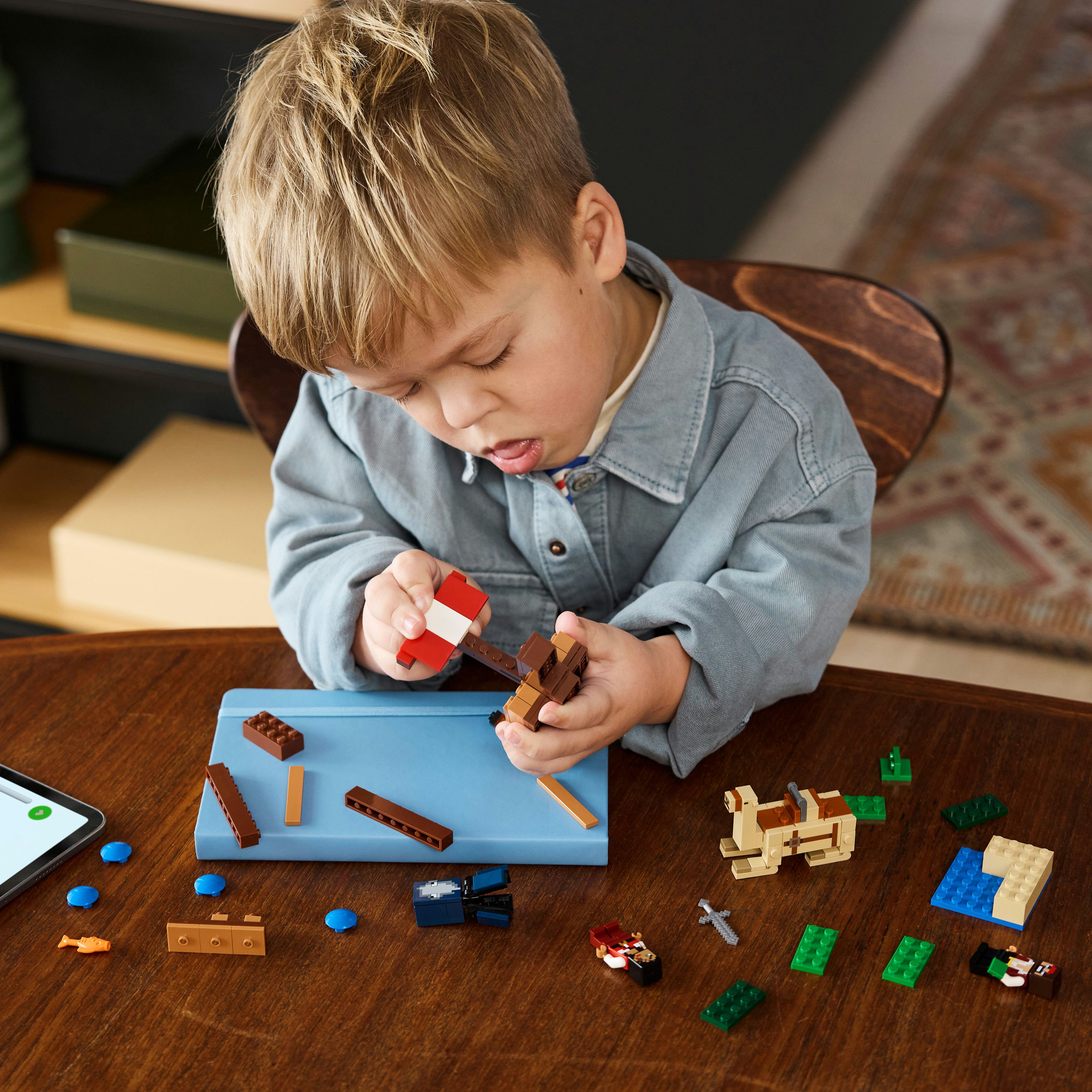 Een kind dat Lego-blokken in elkaar zet op een blauw oppervlak.