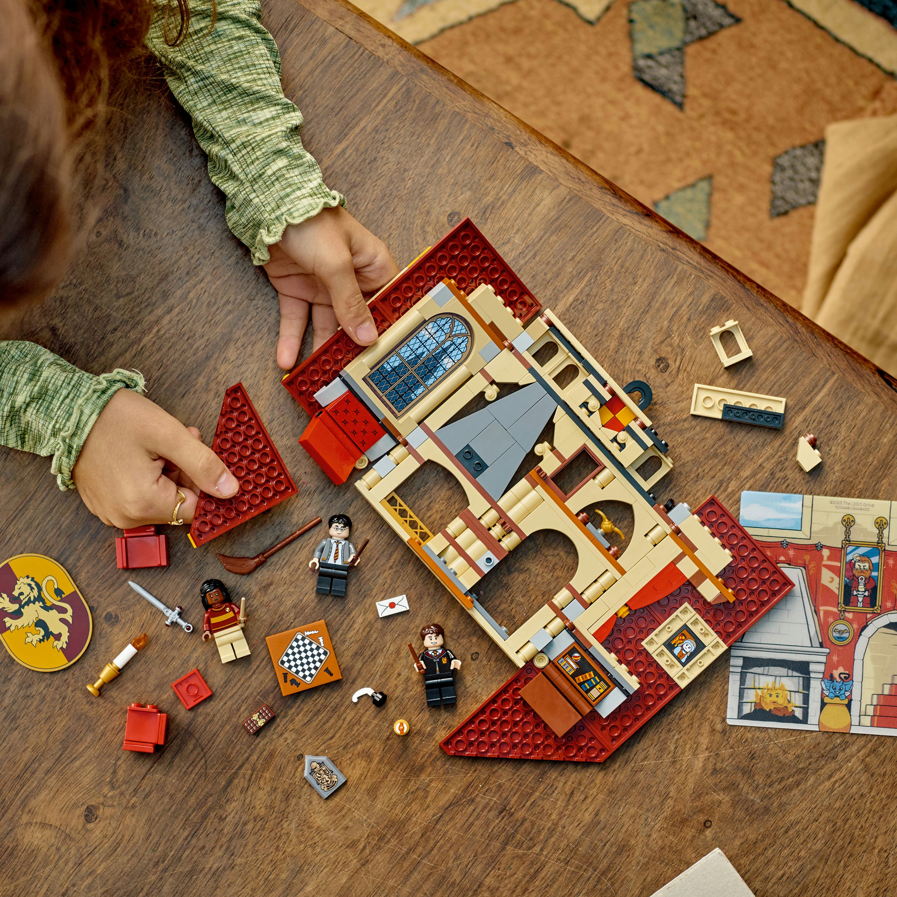 LEGO Harry Potter Set. Offenes Buch mit Figuren, Schachbrett und verschiedenen Minifiguren auf Holz.