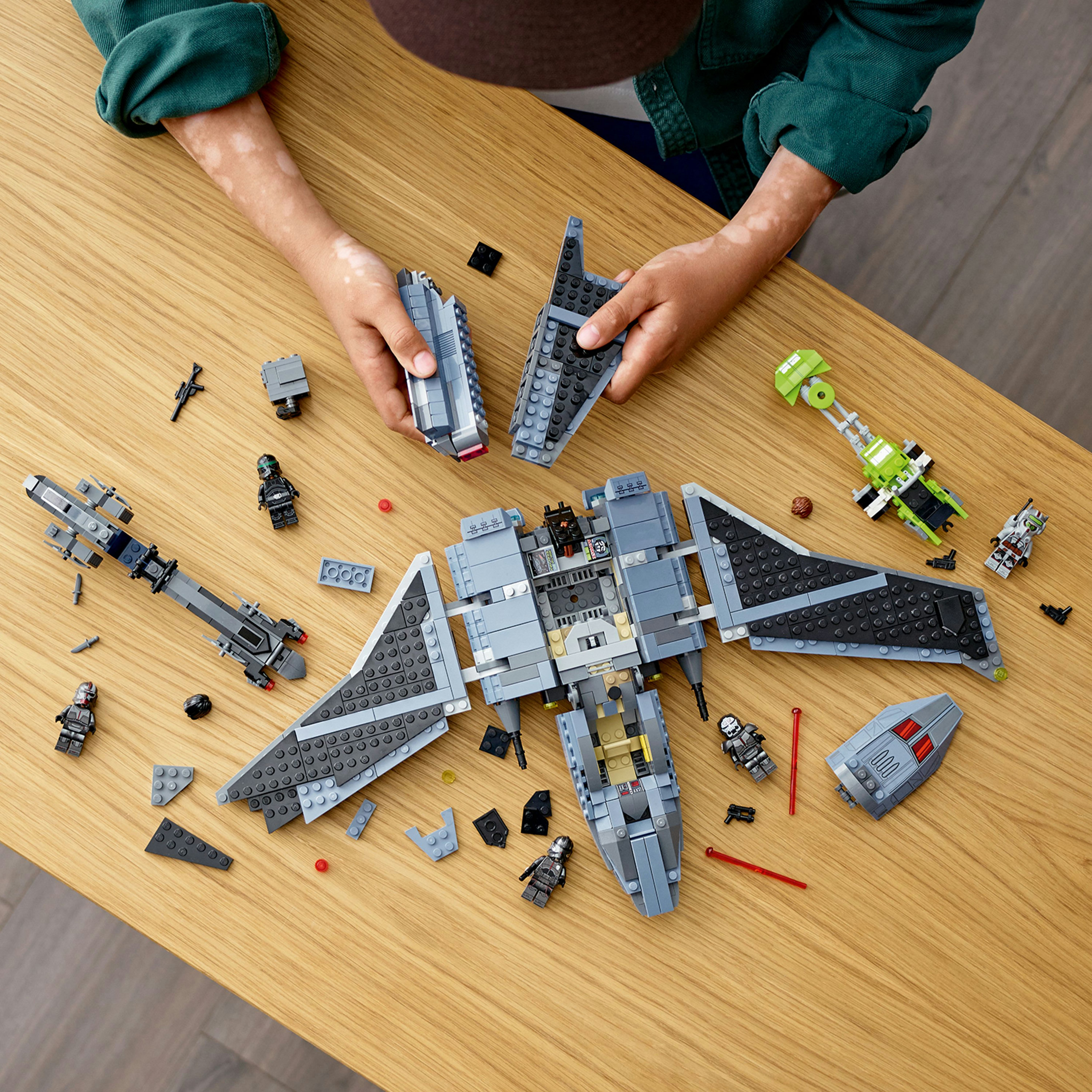 Modèles LEGO sur une étagère, y compris des maisons, des figurines et des blocs de construction.