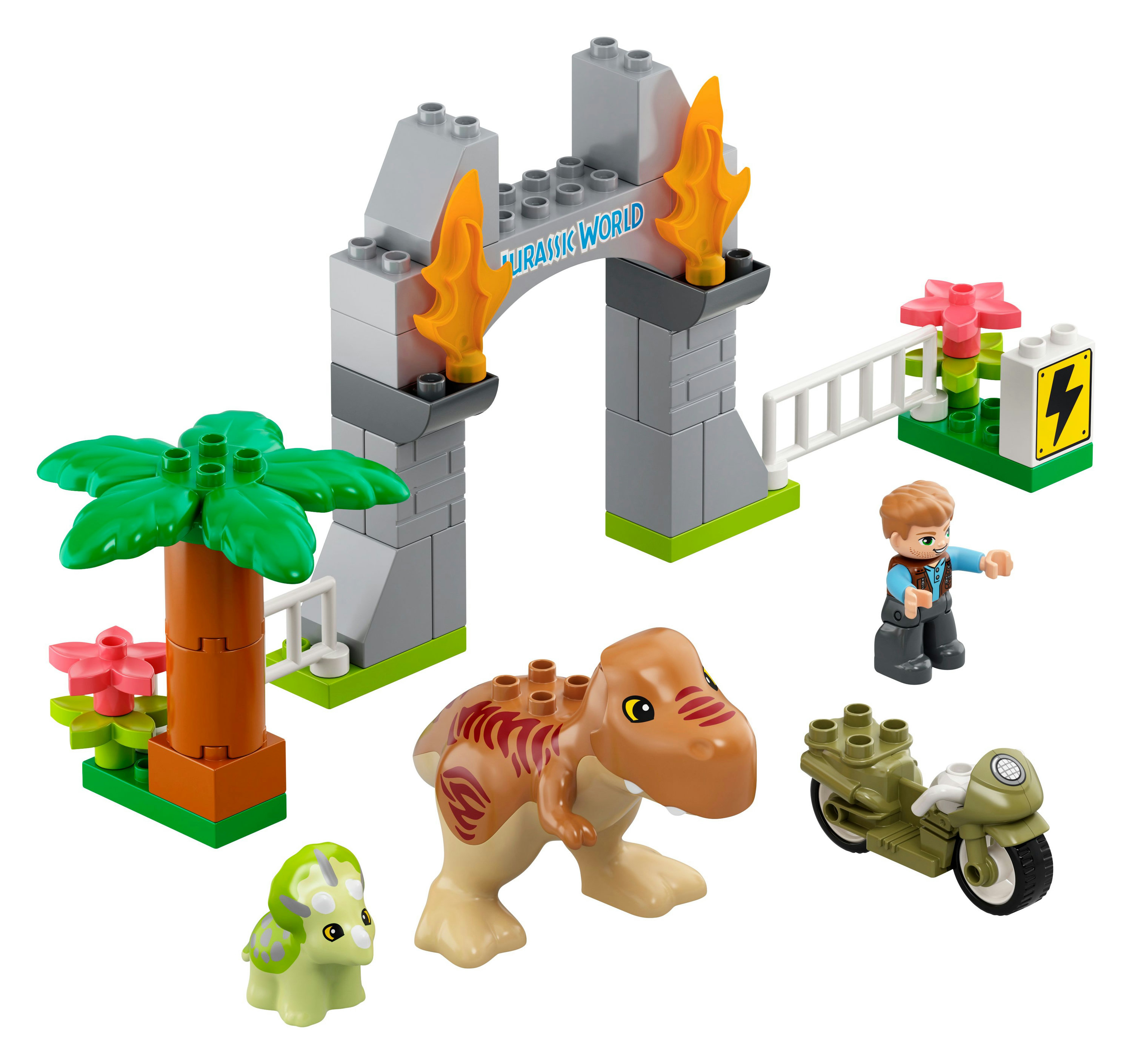 Un set Lego Duplo Jurassic World. Include un dinosauro, un cancello, una palma e una figura. Su sfondo bianco.