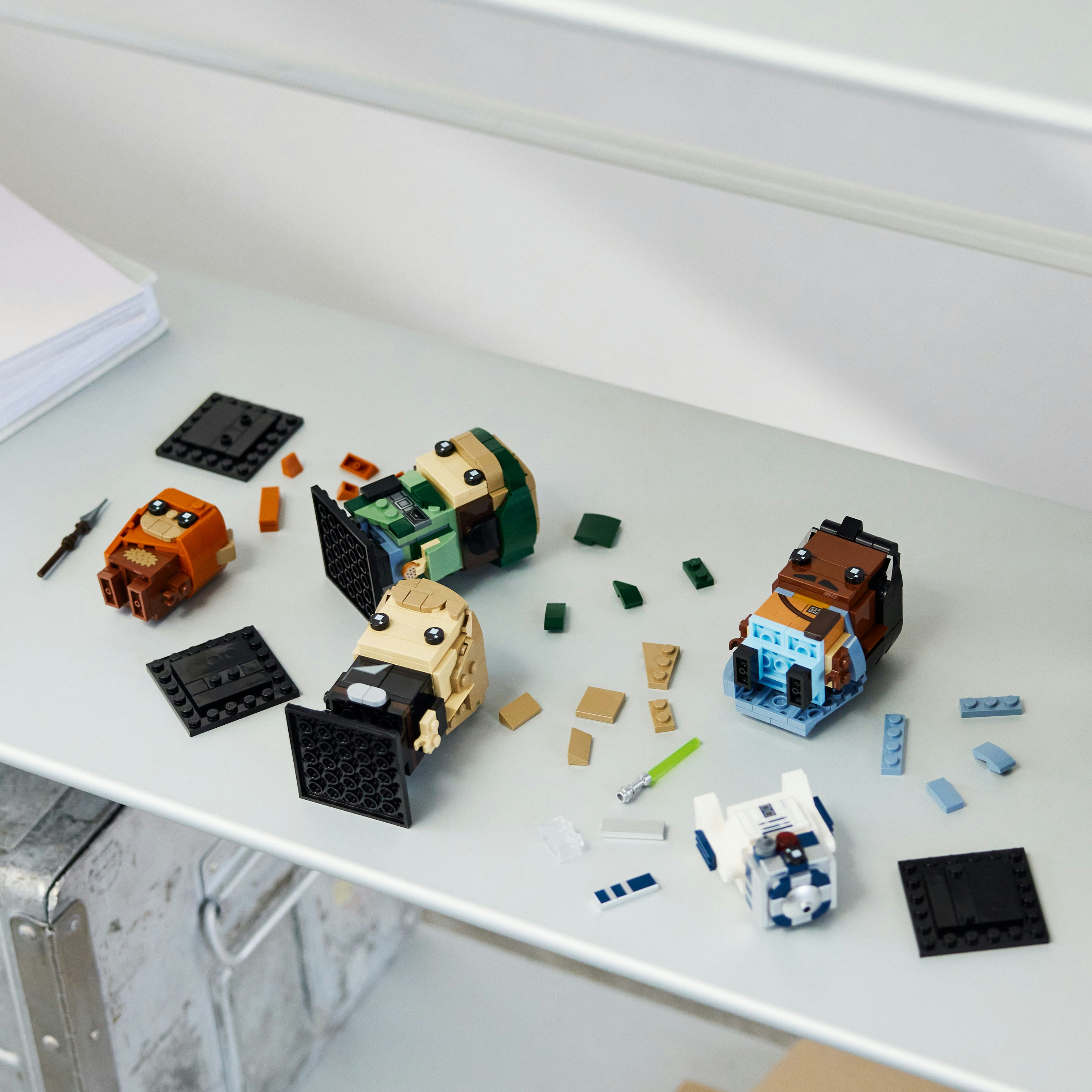 Eine LEGO Minecraft Set-Box mit einem Gebäude und Figuren auf einer grasbewachsenen Landschaft.