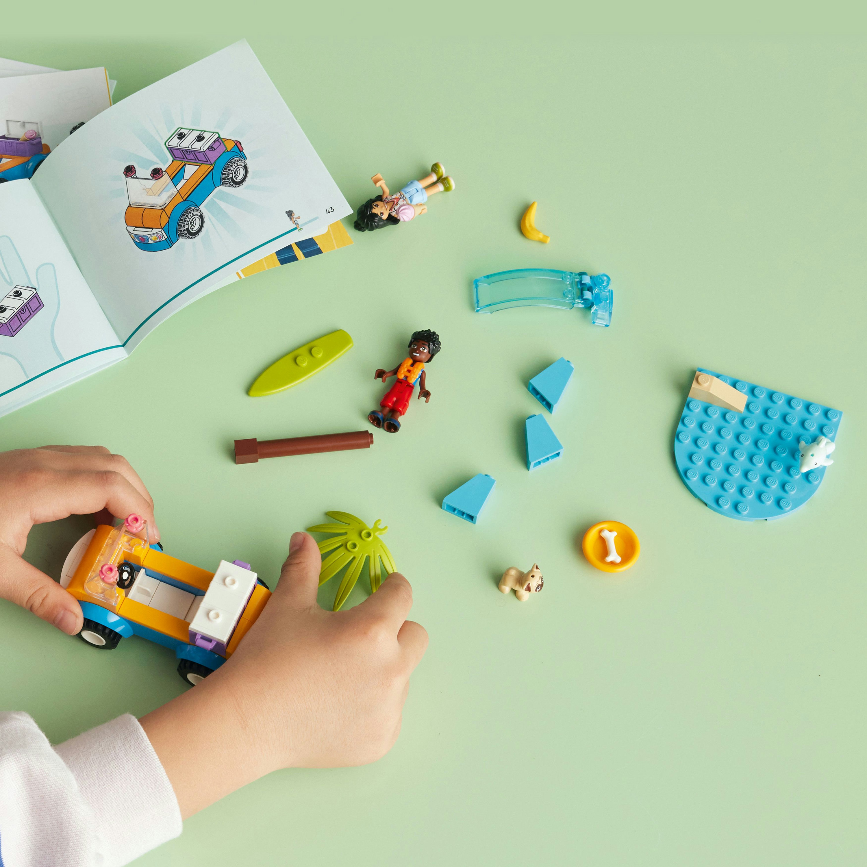 Een kind dat Lego-stukjes in elkaar zet. Lego-set met een auto, figuren en een strandscène.
