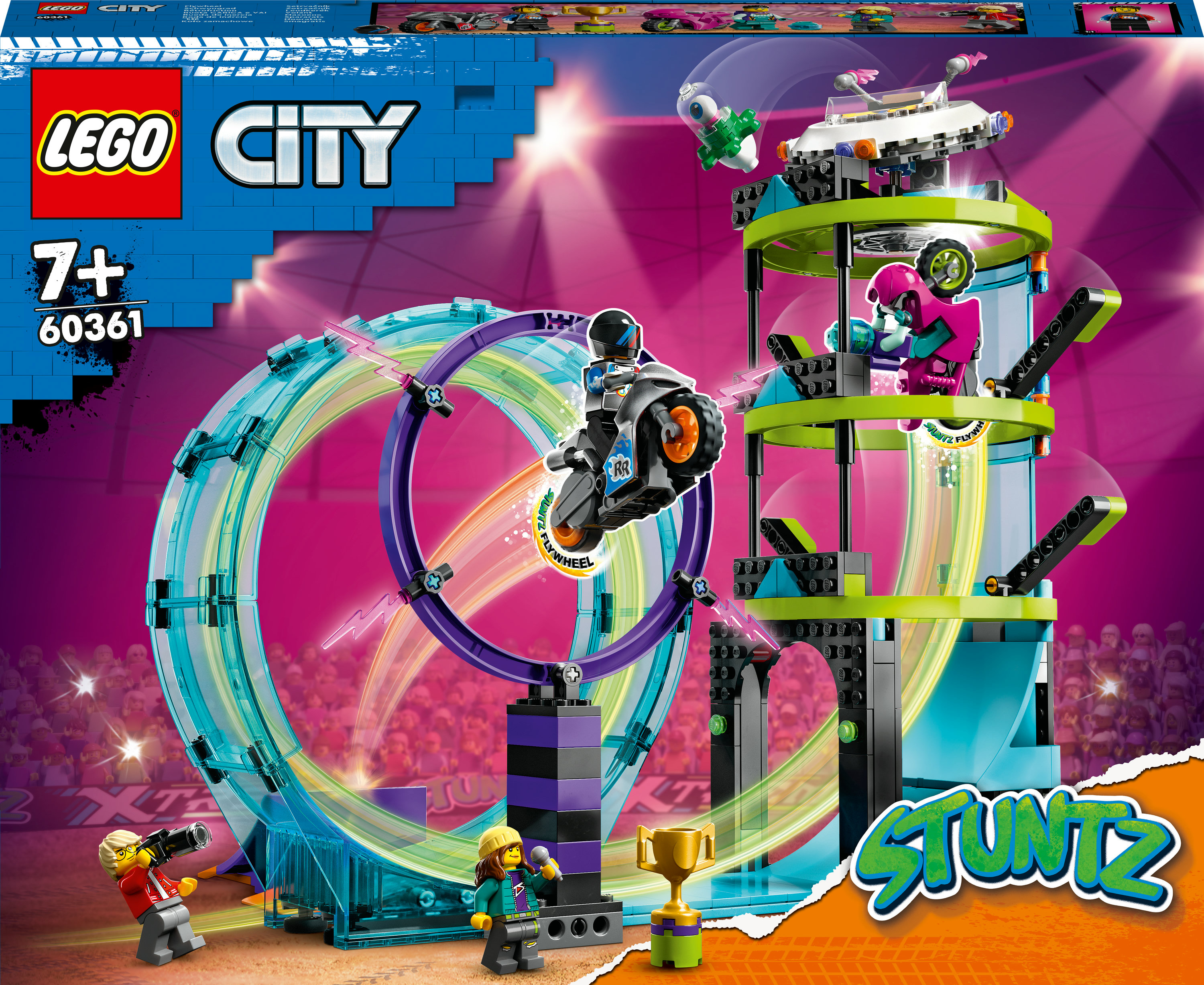 Bir Lego City seti, parlak renkli bir arenada bir döngü, motosiklet ve figürlerle bir akrobasi şovunu gösteriyor.